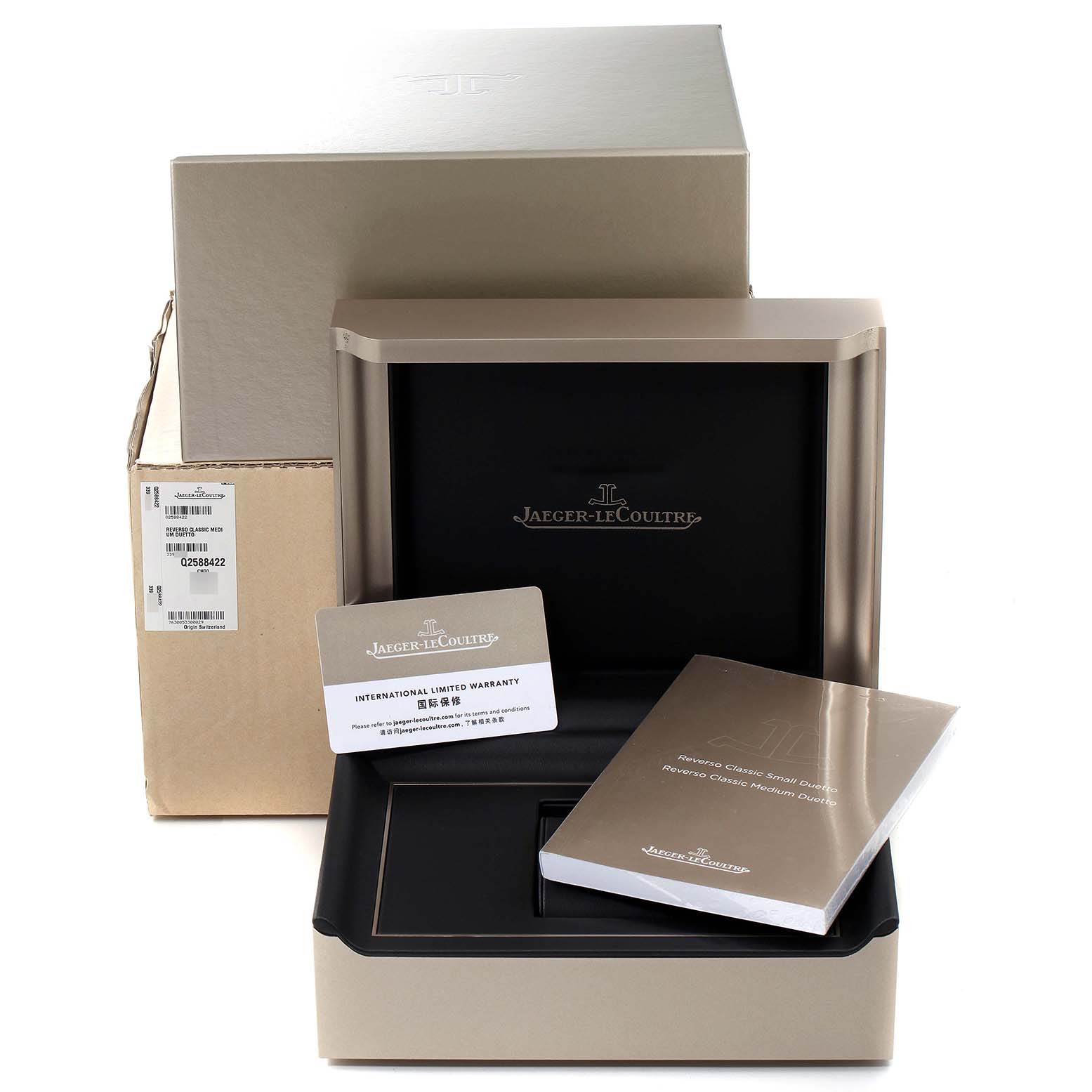 The image shows the packaging, warranty card, and manual for a Jaeger-LeCoultre Reverso model watch.