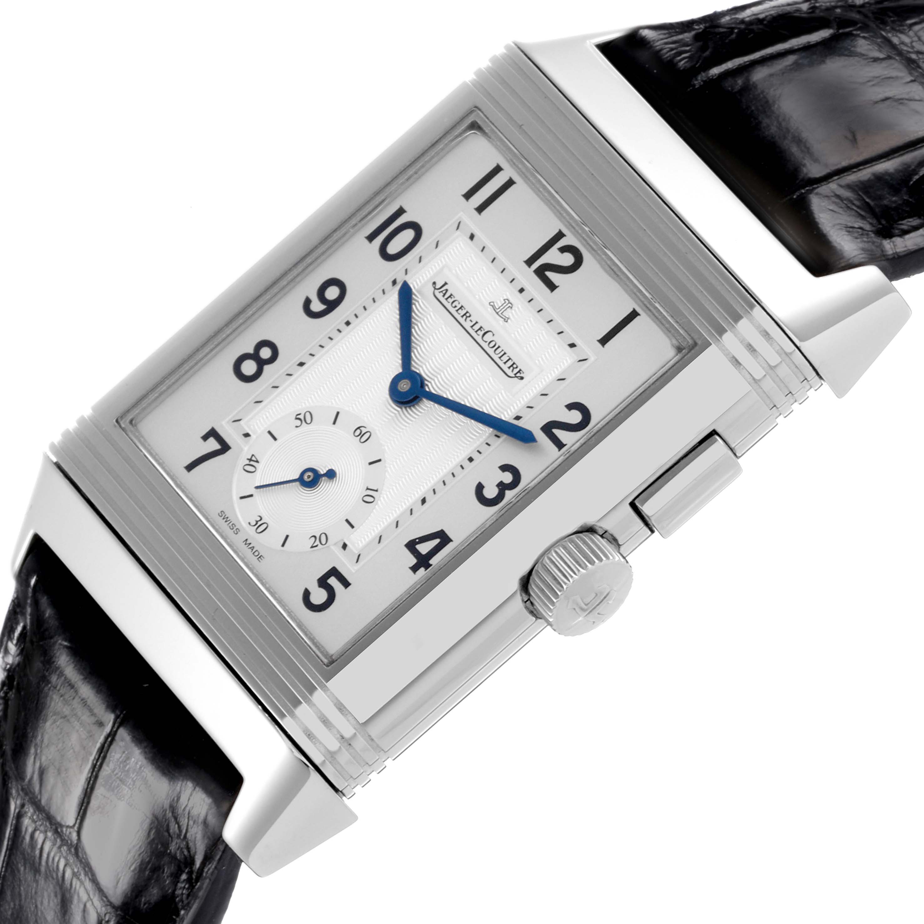 The image shows a Jaeger-LeCoultre Reverso watch at an angled close-up, highlighting the face, crown, and strap.