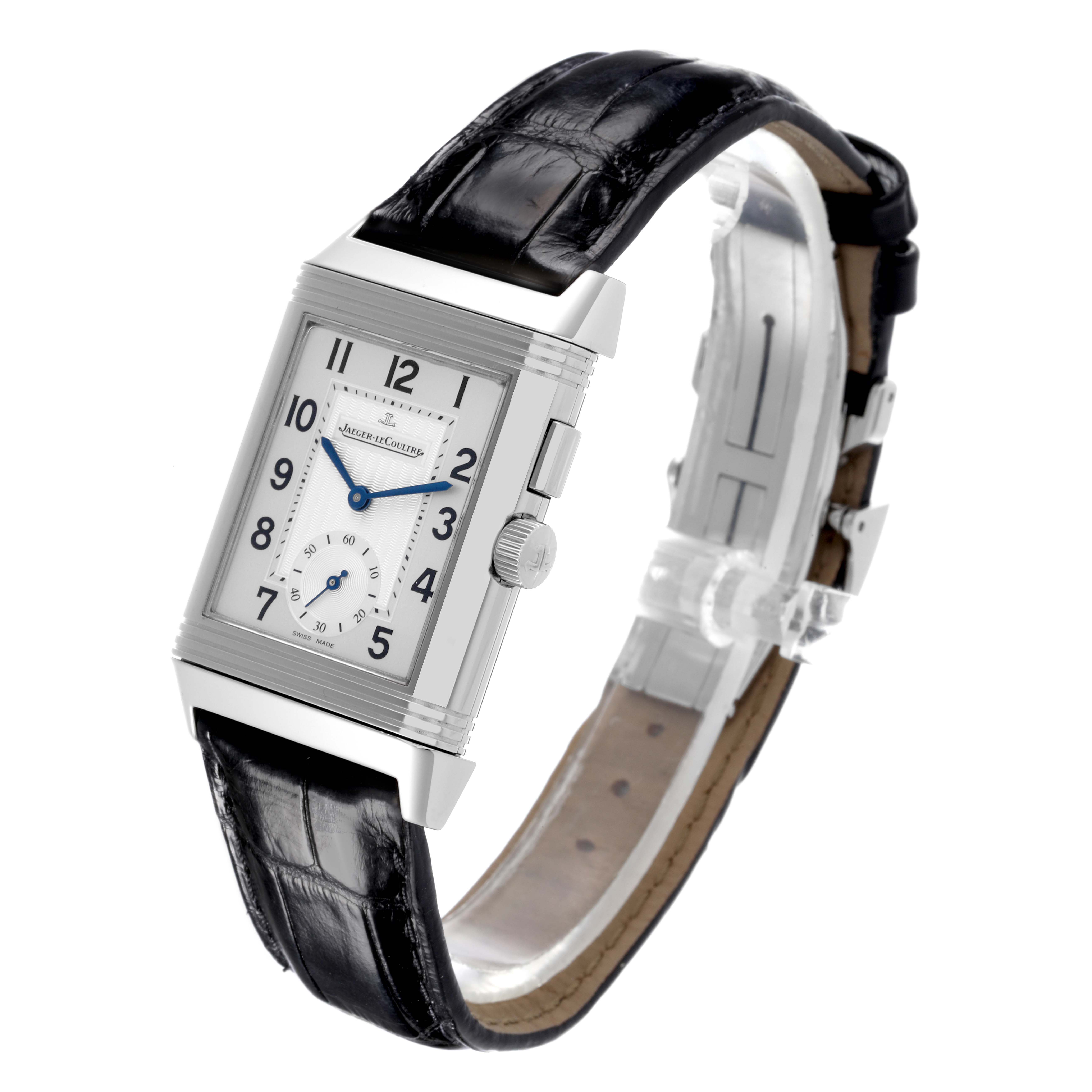 The Jaeger-LeCoultre Reverso watch is shown at an angle highlighting its rectangular face, dial, and alligator leather strap.