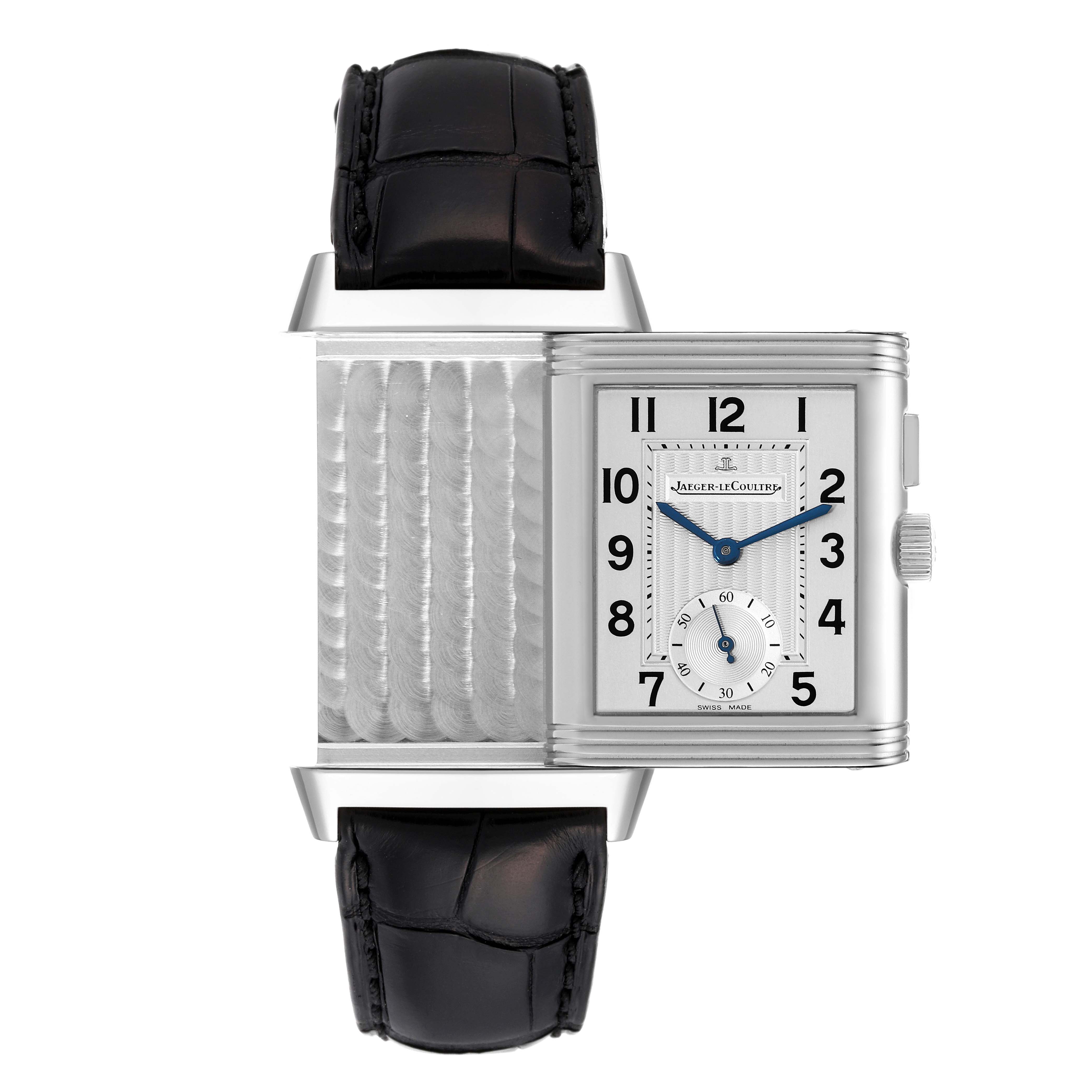 The Jaeger-LeCoultre Reverso watch is shown with its reversible case open, displaying both the inner engraving and the dial.