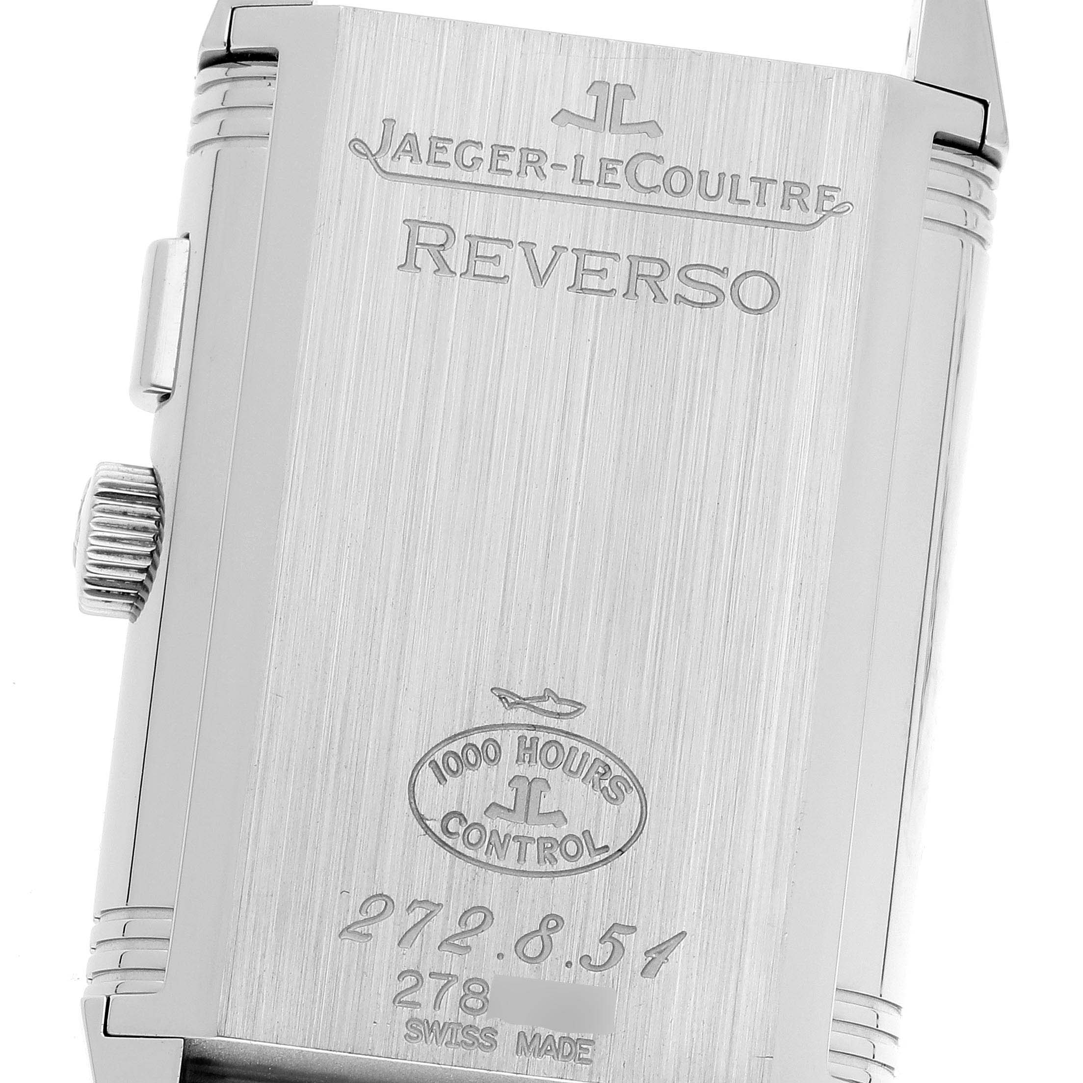 The image shows the back case of a Jaeger-LeCoultre Reverso watch, highlighting its engraved details and crown on the side.