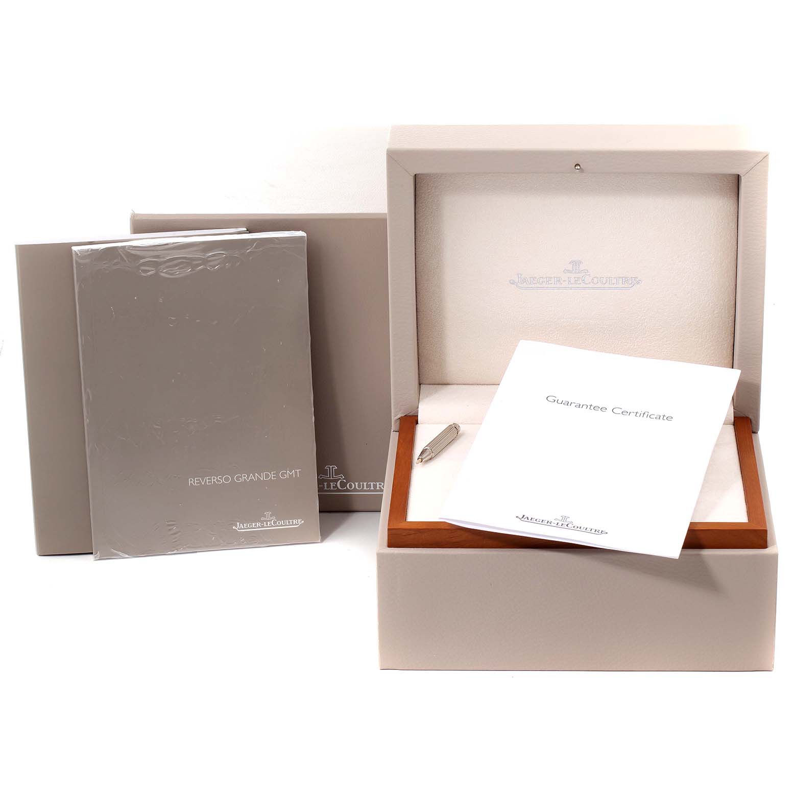 The image shows the Jaeger-LeCoultre Reverso watch box, guarantee certificate, manual, and a small tool from a front angle.