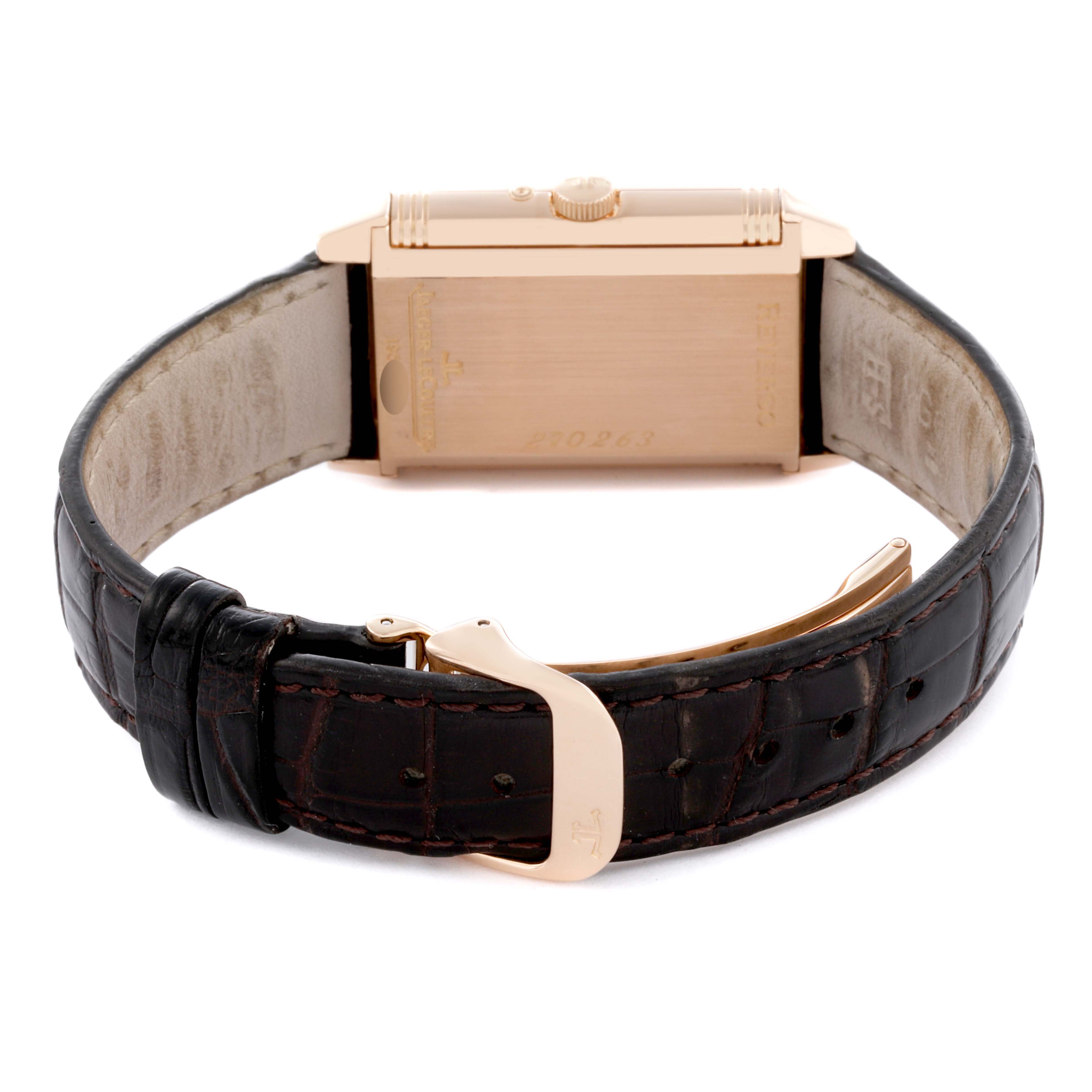 The image shows the back of the Jaeger-LeCoultre Reverso watch, highlighting its rectangular case and leather strap with a clasp.