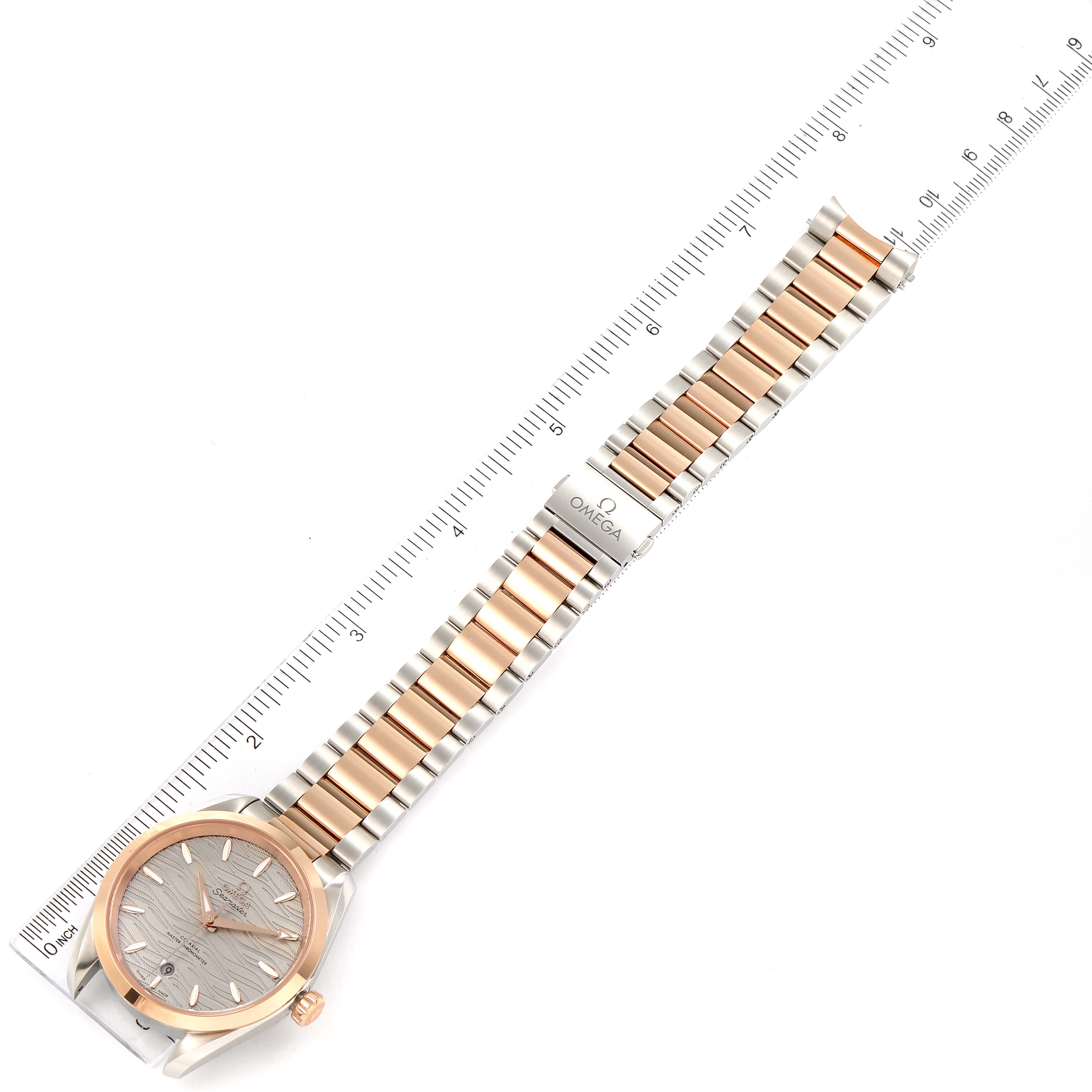 The Omega 220.20.38.20.06.001 Women
s Steel and Gold (two tone) Grey Dial 220.20.38.20.06.001 Women
s Steel and Gold (two tone) Grey Dial Seamaster Aqua Terra Steel Rose Gold Watch 220.20.38.20.06.001 is displayed flat, showing its bracelet and face with a ruler for scale.