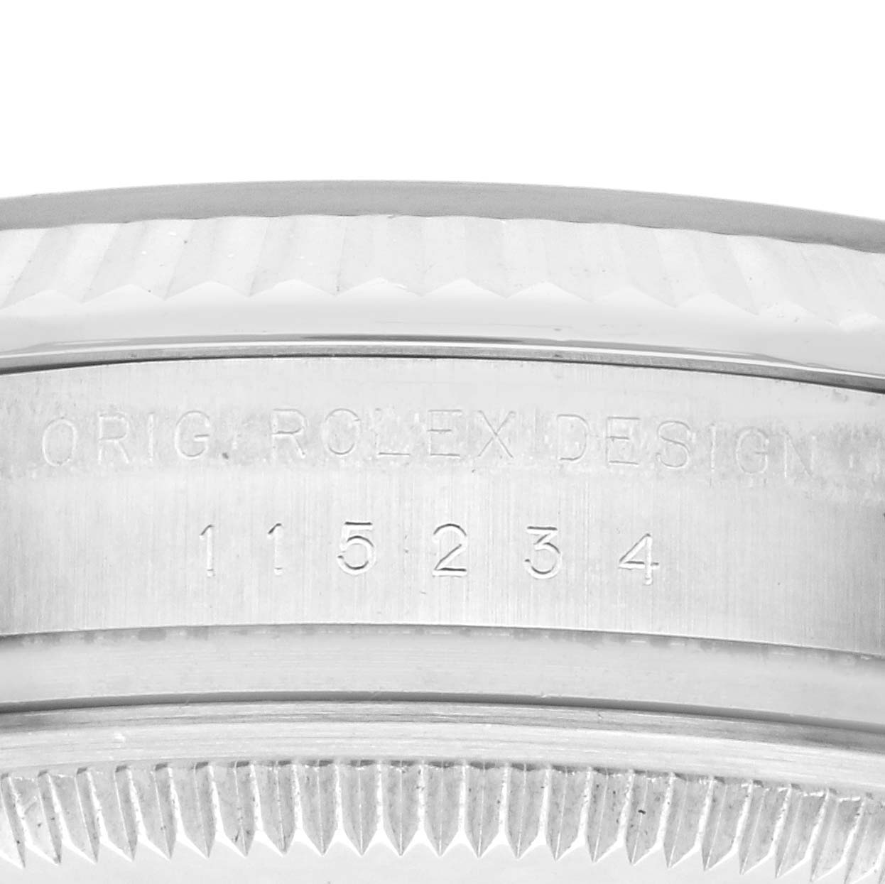 The image shows the side of the bezel and the engraved serial number on a Rolex Date 115234 Men's Stainless Steel Black Dial 115234 Men's Stainless Steel Black Dial model watch.