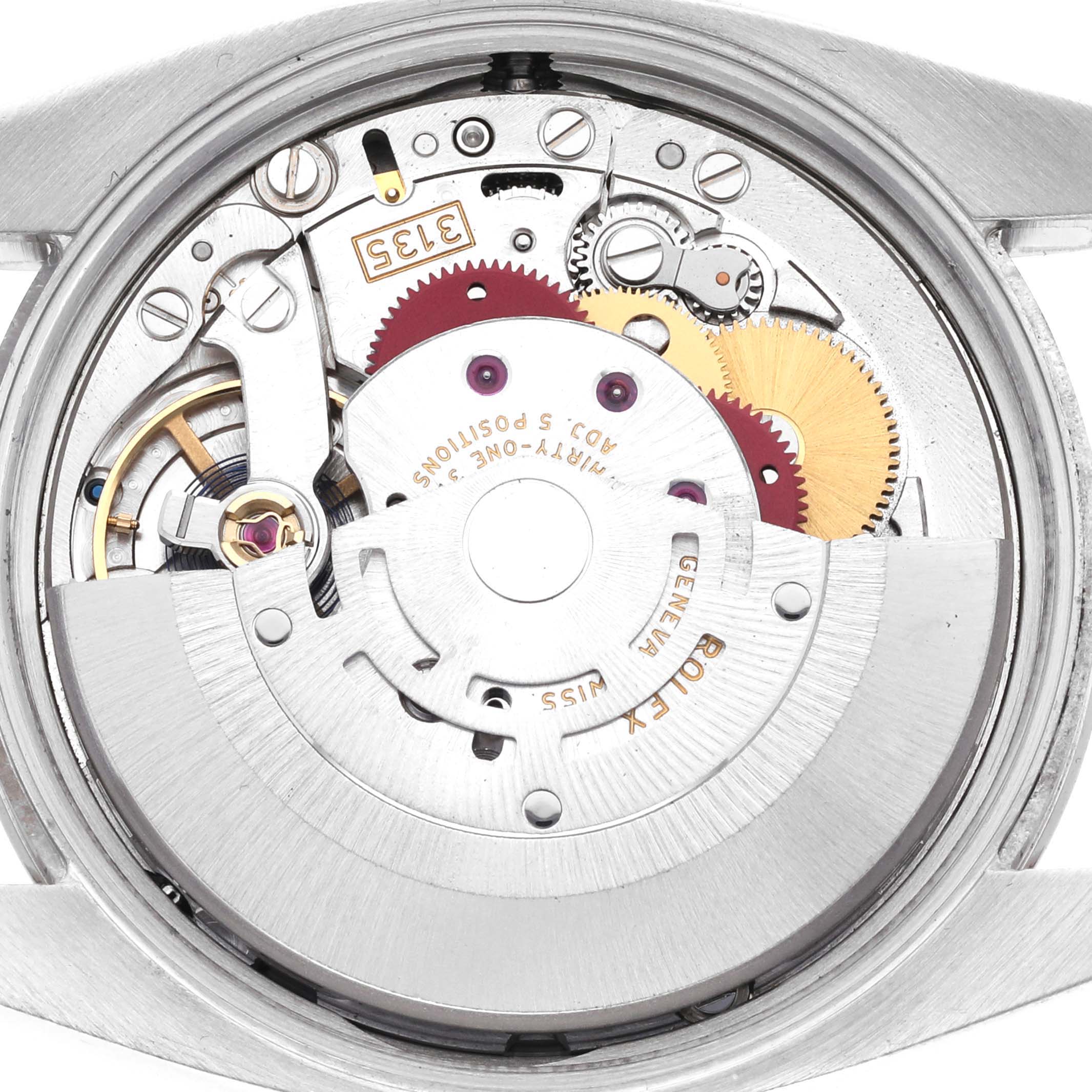The image shows a close-up of the movement inside a Rolex Date 115234 Men's Stainless Steel Black Dial 115234 Men's Stainless Steel Black Dial watch from the back.