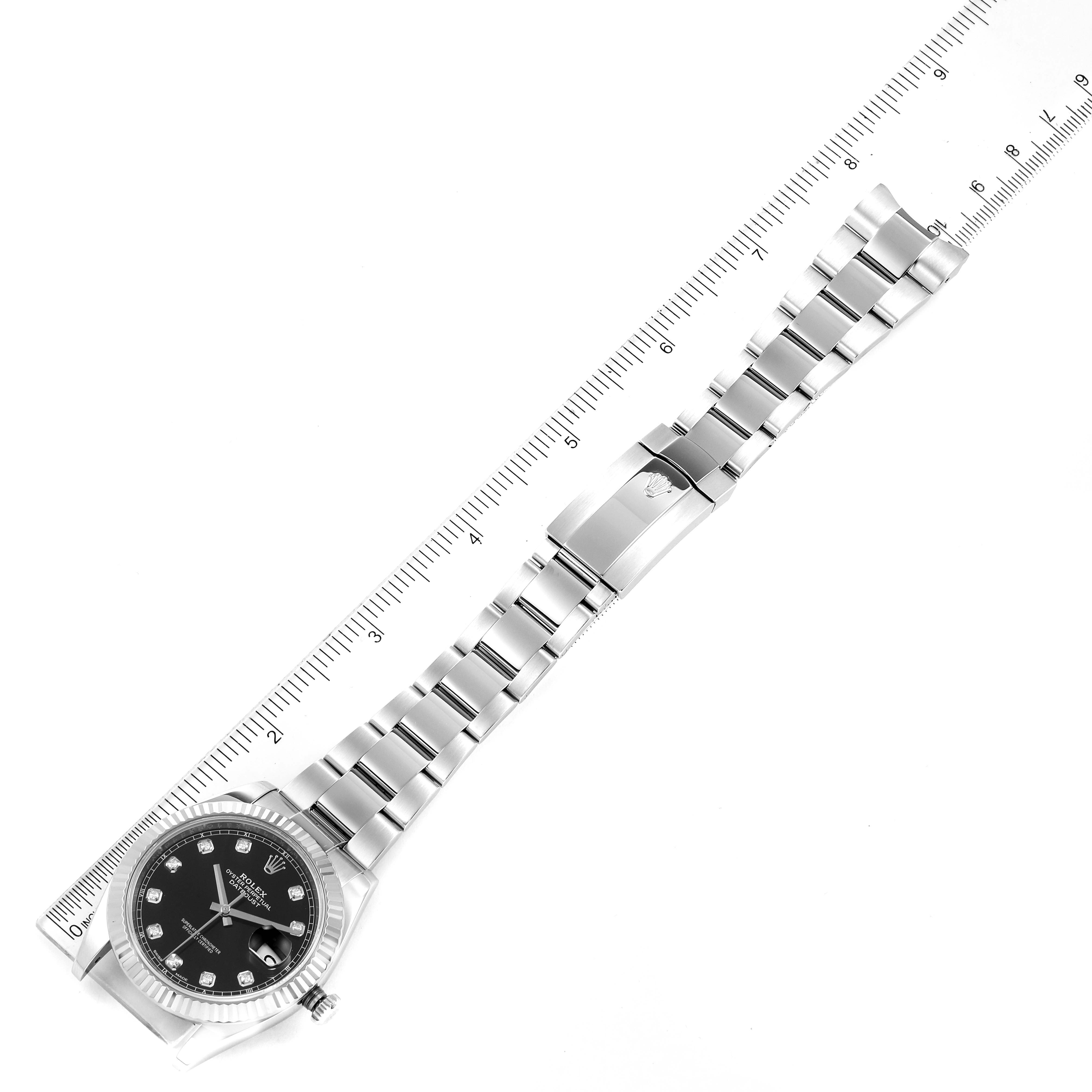 The image shows a top-down view of a Rolex Datejust 41 126334 Men
s Stainless Steel Black Dial 126334 Men
s Stainless Steel Black Dial watch with its full bracelet and a measuring ruler.