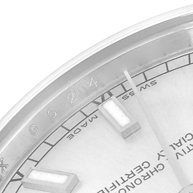 This image shows a close-up of the dial and markers on the Mid-Size Rolex watch, focusing on part of the bezel and face.