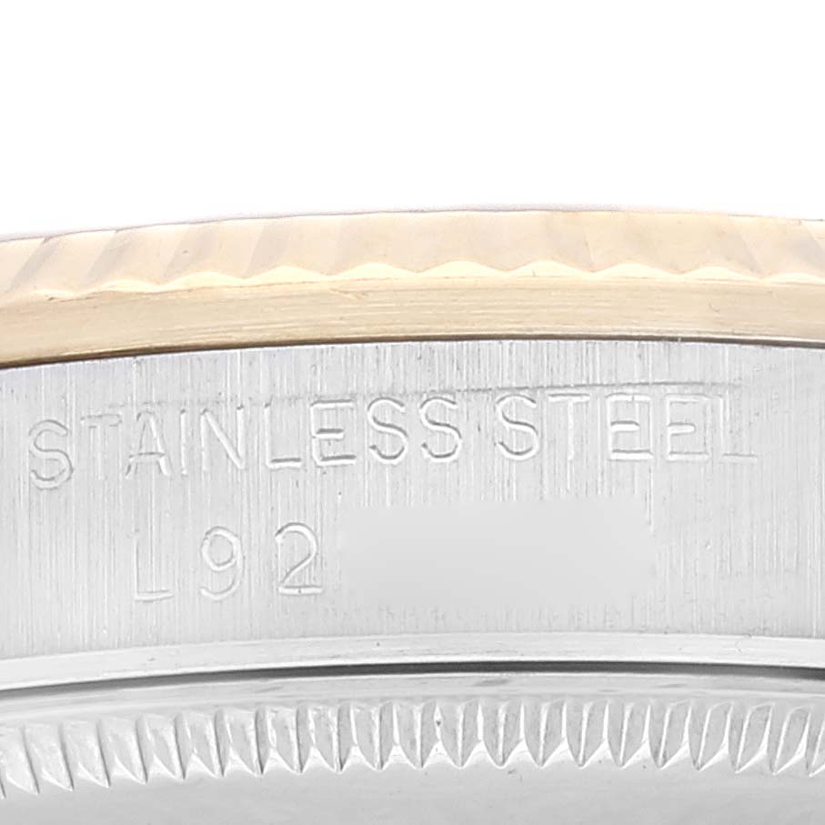 This close-up image shows the side engraving and part of the bezel of a Mid-Size model by Rolex, featuring "STAINLESS STEEL L92."