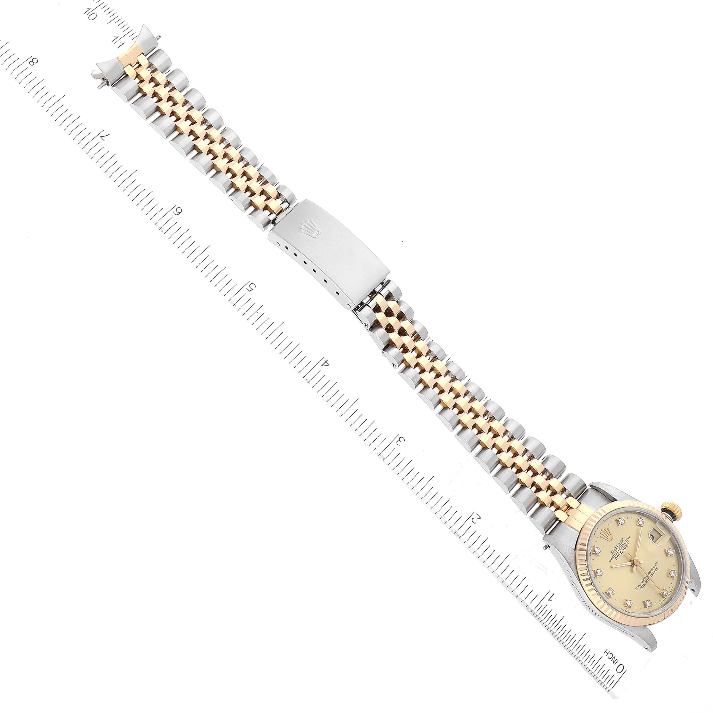 The image shows a Mid-Size Rolex watch laid out flat from a top-down angle, displaying the face and bracelet with a ruler for scale.