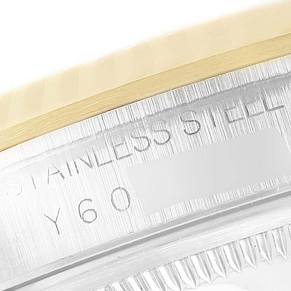 This image shows a close-up of the stainless steel and gold bezel on a Rolex Datejust 16233G Men's Steel and Gold (two tone) Silver Dial 16233G Men's Steel and Gold (two tone) Silver Dial watch, featuring part of the engraved text.