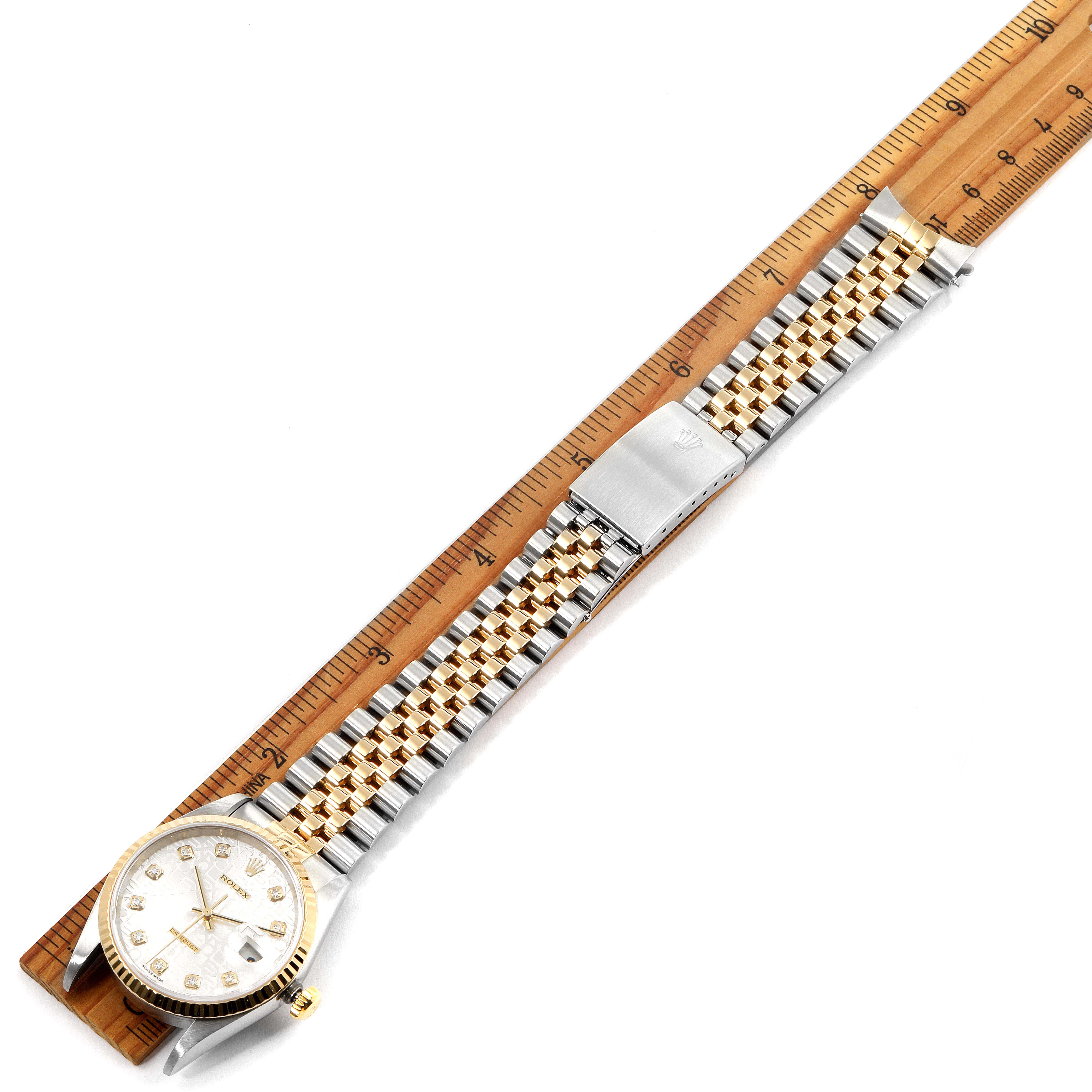 The image shows a Rolex Datejust 16233G Men's Steel and Gold (two tone) Silver Dial 16233G Men's Steel and Gold (two tone) Silver Dial watch laid flat next to a measuring ruler, displaying its face, bezel, bracelet, and clasp.