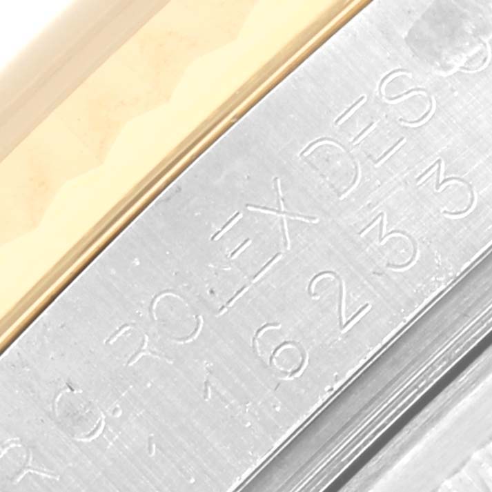 The image shows a close-up of the engraved side of a Rolex Datejust 116233 Men's Steel and Gold (two tone) Champagne Dial 116233 Men's Steel and Gold (two tone) Champagne Dial's bezel and case in metal.