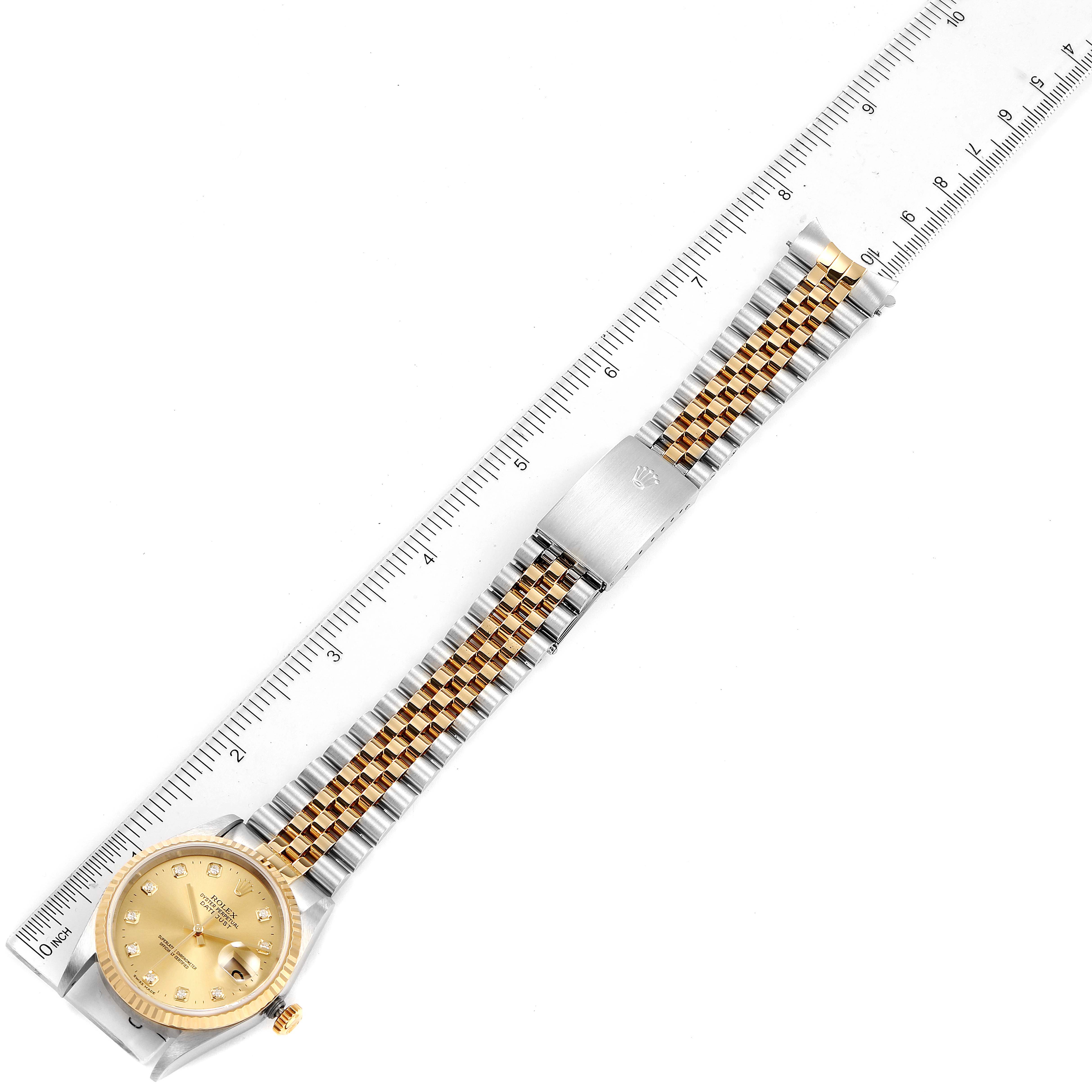 The image shows an aerial view of a Rolex Datejust 16233 Men's Steel and Gold (two tone) Champagne Dial 16233 Men's Steel and Gold (two tone) Champagne Dial watch, showcasing the dial, bezel, bracelet, clasp, and crown with a ruler for scale.
