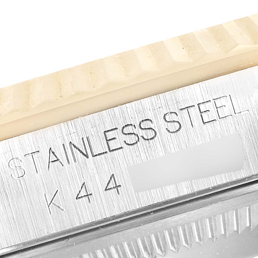 This image shows a close-up of the bezel and case of a Rolex Datejust 16233 Men's Steel and Gold (two tone) Champagne Dial 16233 Men's Steel and Gold (two tone) Champagne Dial watch, highlighting the "STAINLESS STEEL" engraving.