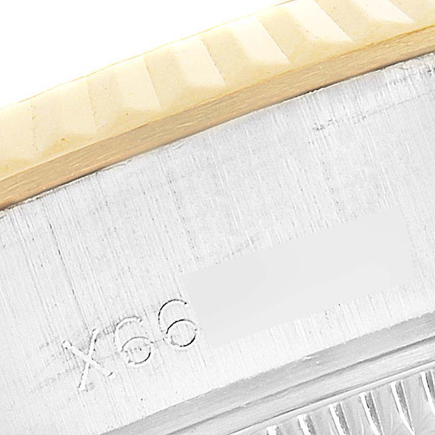 This image shows a close-up of the Rolex Datejust 69173 Women's Steel and Gold (two tone) Champagne Dial 69173 Women's Steel and Gold (two tone) Champagne Dial model's case side with part of the fluted bezel and serial number.