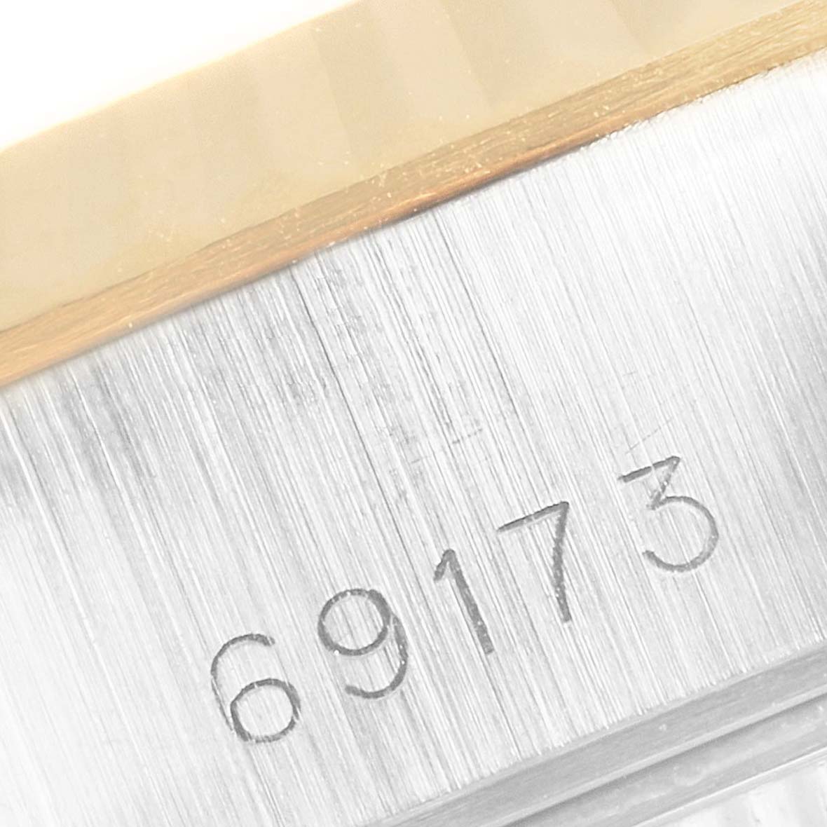 This image shows a close-up angle of the Rolex Datejust 69173 Women's Steel and Gold (two tone) Champagne Dial 69173 Women's Steel and Gold (two tone) Champagne Dial model 69173 serial number engraving on the watch case.