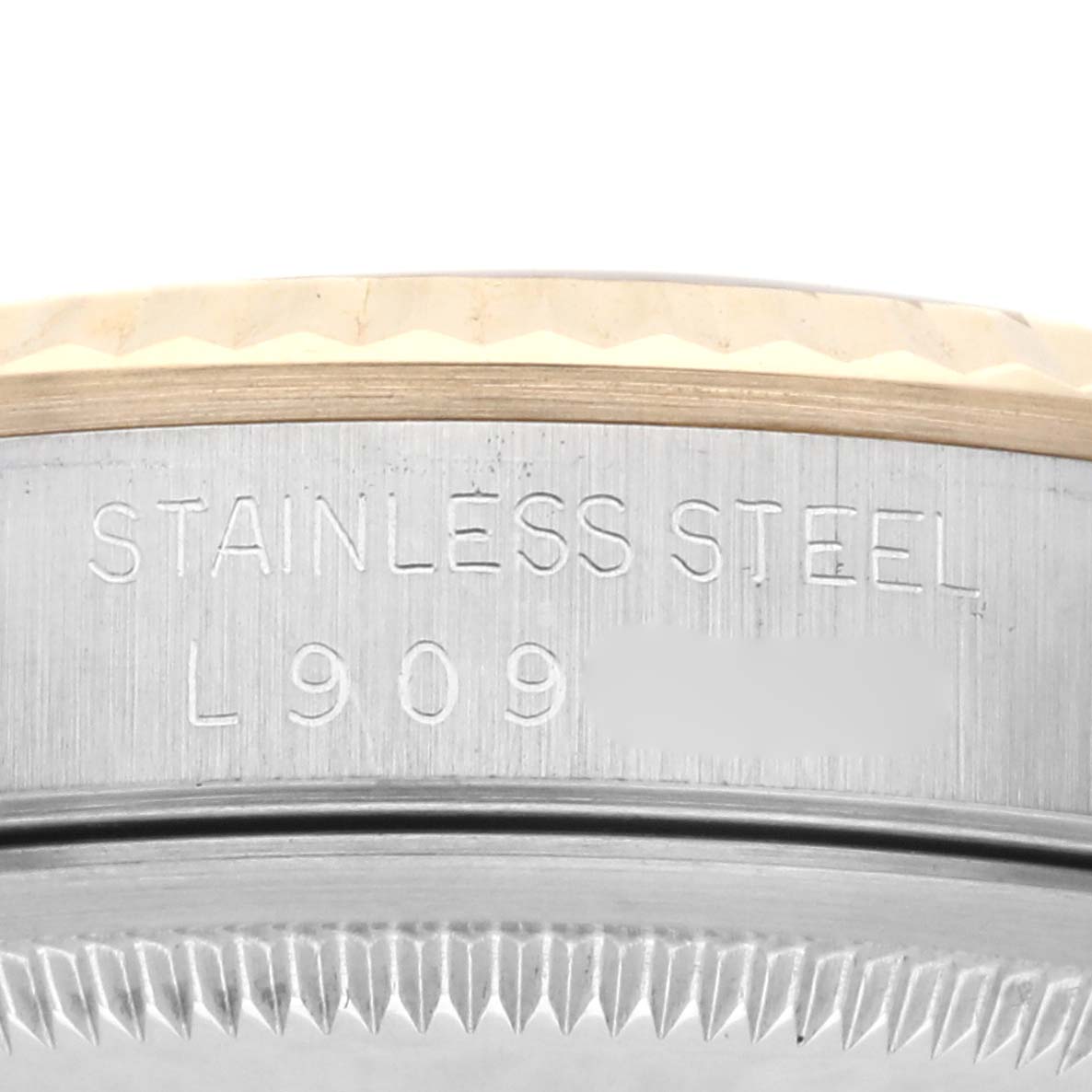 The image shows the side of a Rolex Datejust 16233 Men's Steel and Gold (two tone) Champagne Dial 16233 Men's Steel and Gold (two tone) Champagne Dial's case with stainless steel engraving.
