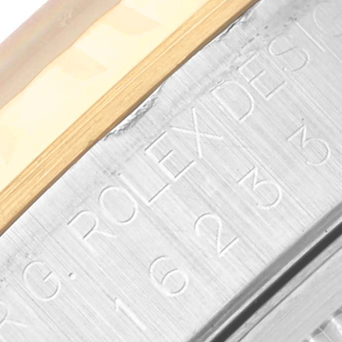 The image shows a close-up of the engraved side of a Rolex Datejust 16233 Men's Steel and Gold (two tone) Blue Dial 16233 Men's Steel and Gold (two tone) Blue Dial watch case.