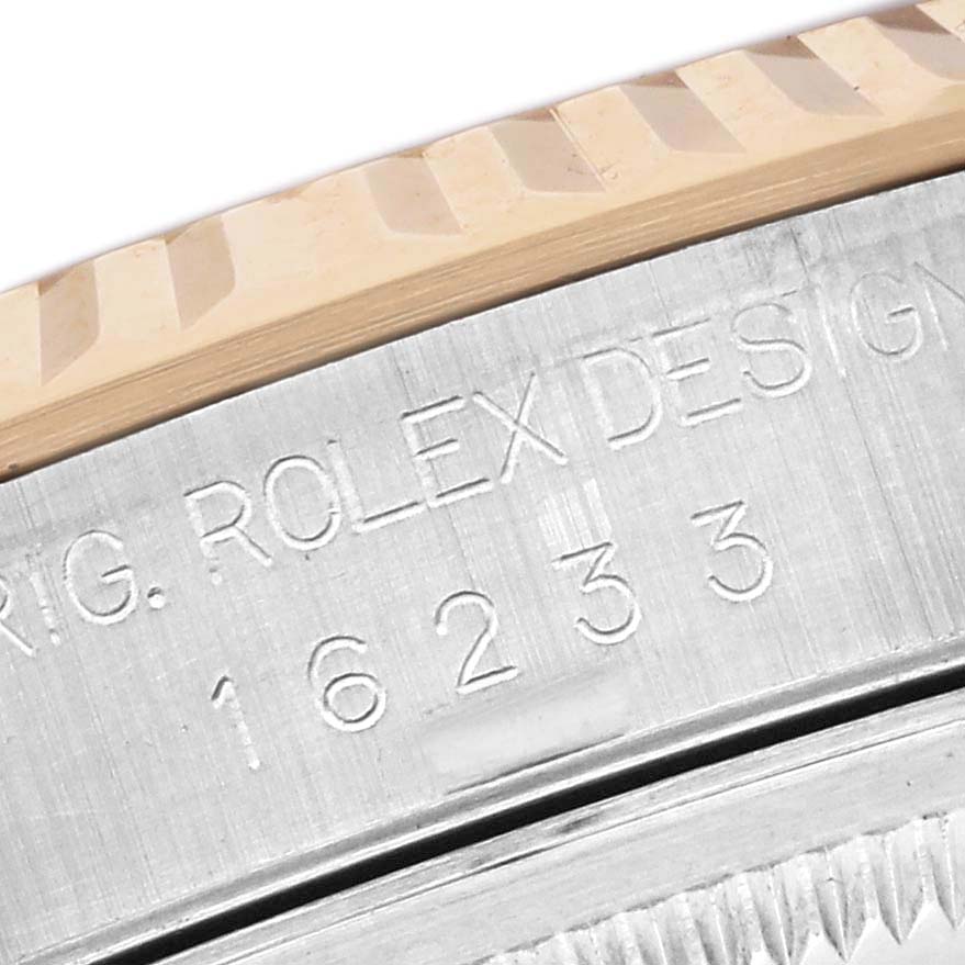 This image shows a close-up of the serial number and fluted bezel of a Rolex Datejust 16233 Men's Steel and Gold (two tone) White Dial 16233 Men's Steel and Gold (two tone) White Dial watch.