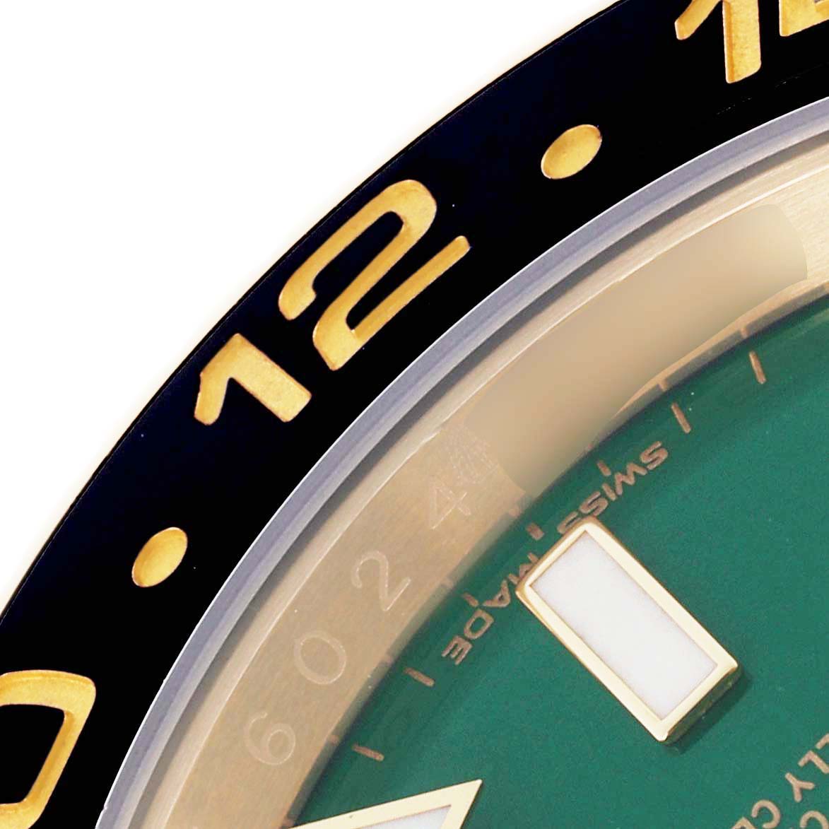 The image shows a close-up of the Rolex GMT-Master 116718 Men's Yellow Gold Green Dial 116718 Men's Yellow Gold Green Dial's bezel and part of the green dial with a luminous index.