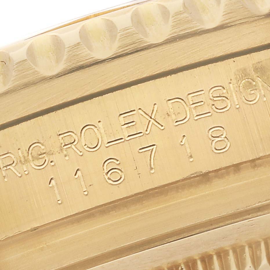The image shows a close-up angle of the Rolex GMT-Master 116718 Men's Yellow Gold Green Dial 116718 Men's Yellow Gold Green Dial model case with its engraved serial number.