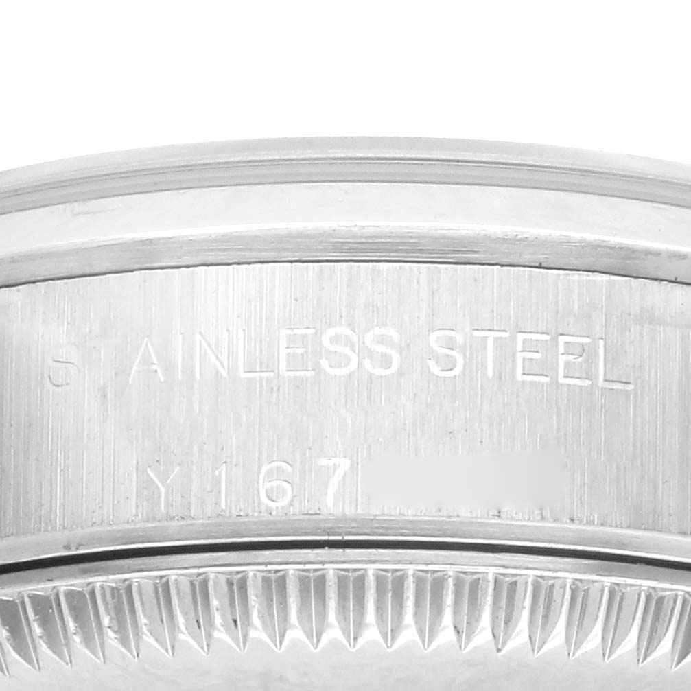 The image shows a close-up of the side of a Rolex Oyster Perpetual 76080 Women's Stainless Steel Brown Dial 76080 Women's Stainless Steel Brown Dial watch case, highlighting the "STAINLESS STEEL" engraving.