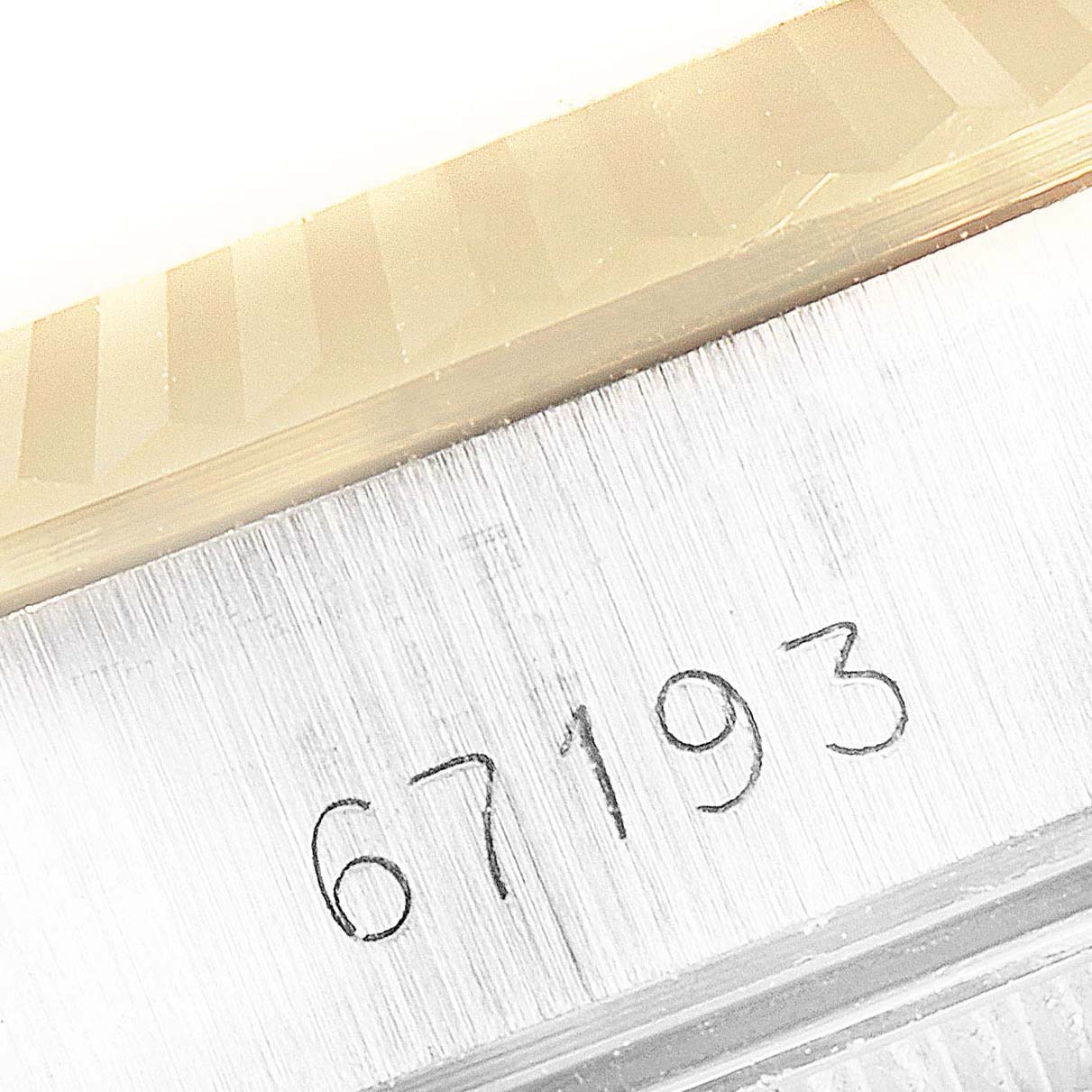 This close-up image shows the engraved model number (67193) on the case of a Rolex Oyster Perpetual 67193 Women
s Steel and Gold (two tone) Champagne Dial 67193 Women
s Steel and Gold (two tone) Champagne Dial watch.