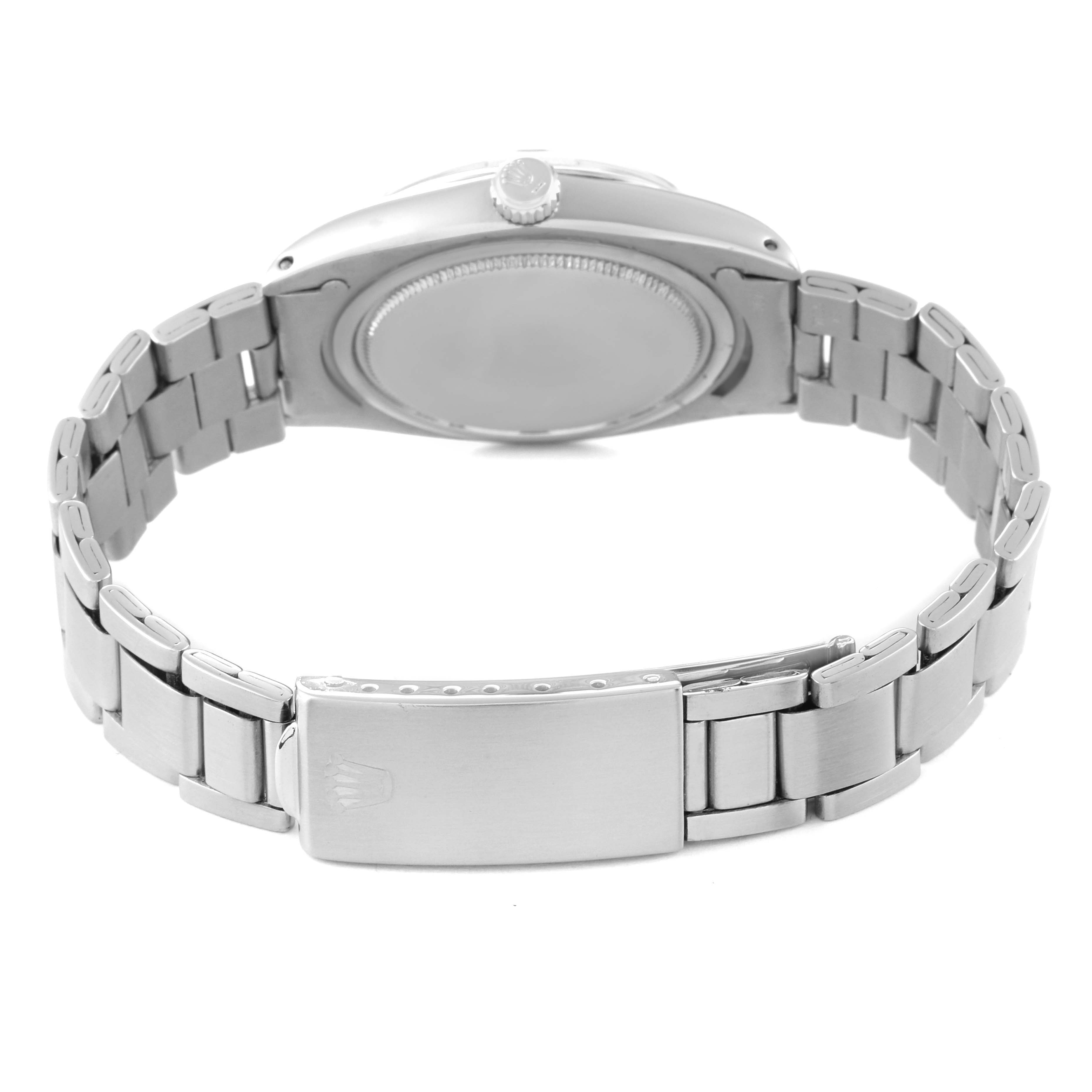 The image shows the back case, crown, and partially opened bracelet of a Vintage Collection model by Rolex.