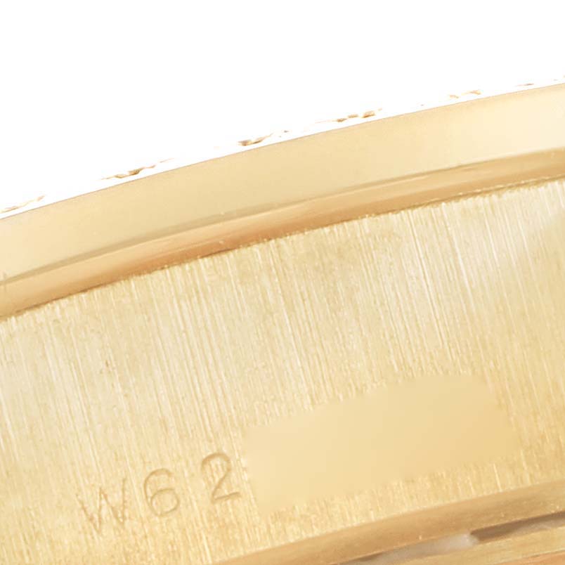 The image shows a close-up of the side of a Rolex President 69138 Women
s Yellow Gold White Dial 69138 Women
s Yellow Gold White Dial model watch, focusing on the edge and part of the case with some inscriptions.