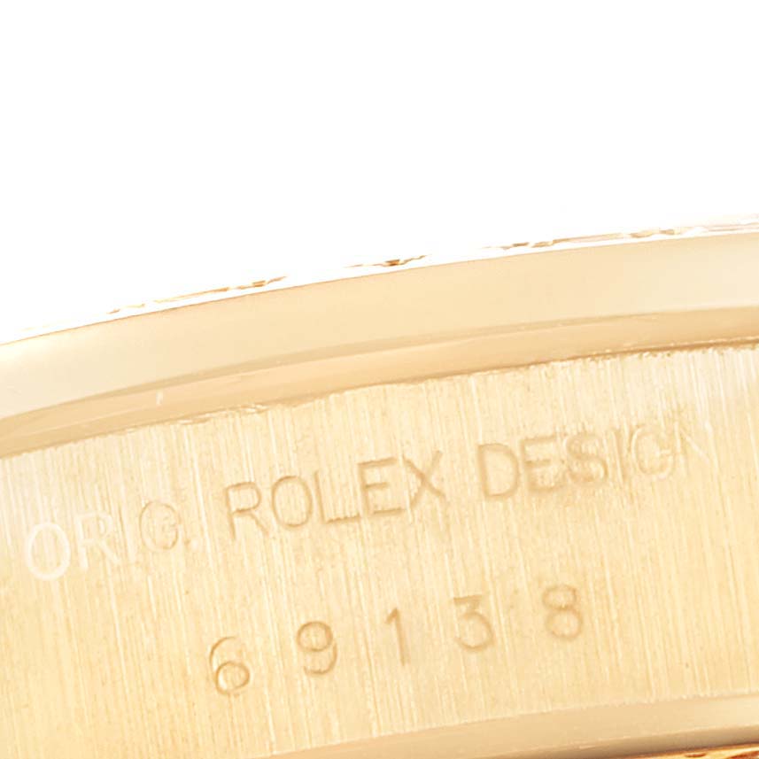 This image shows a close-up of the model number and "ROLEX DESIGN" engraving on the case of a Rolex President 69138 Women
s Yellow Gold White Dial 69138 Women
s Yellow Gold White Dial watch.