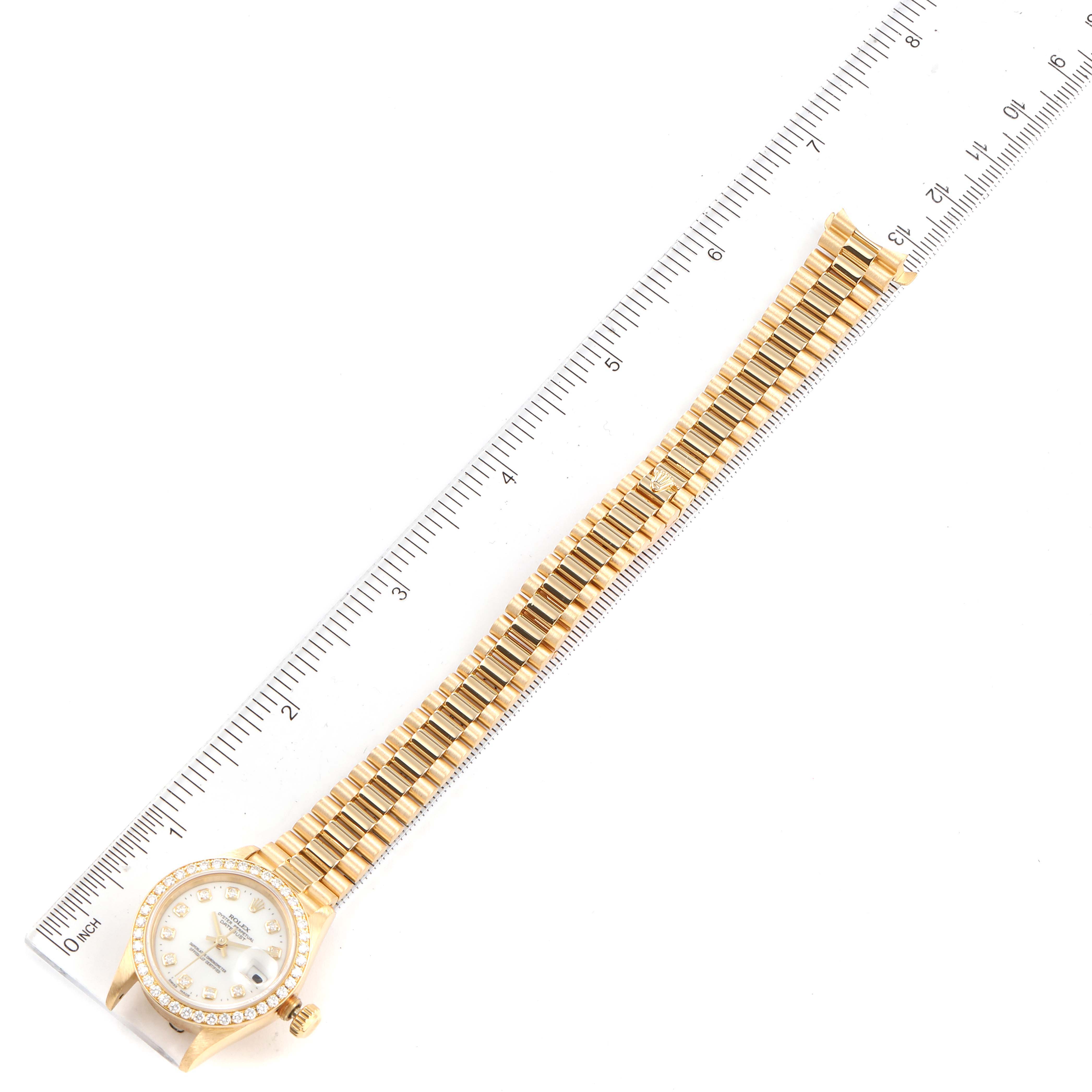 The image shows a full view from above of a Rolex President 69138 Women
s Yellow Gold White Dial 69138 Women
s Yellow Gold White Dial model with a ruler for scale.