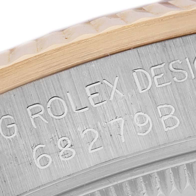 The image shows a close-up of the engraved case edge on a Rolex President 68279 Women
s White Gold Champagne Dial 68279 Women
s White Gold Champagne Dial model, including part of the bezel.