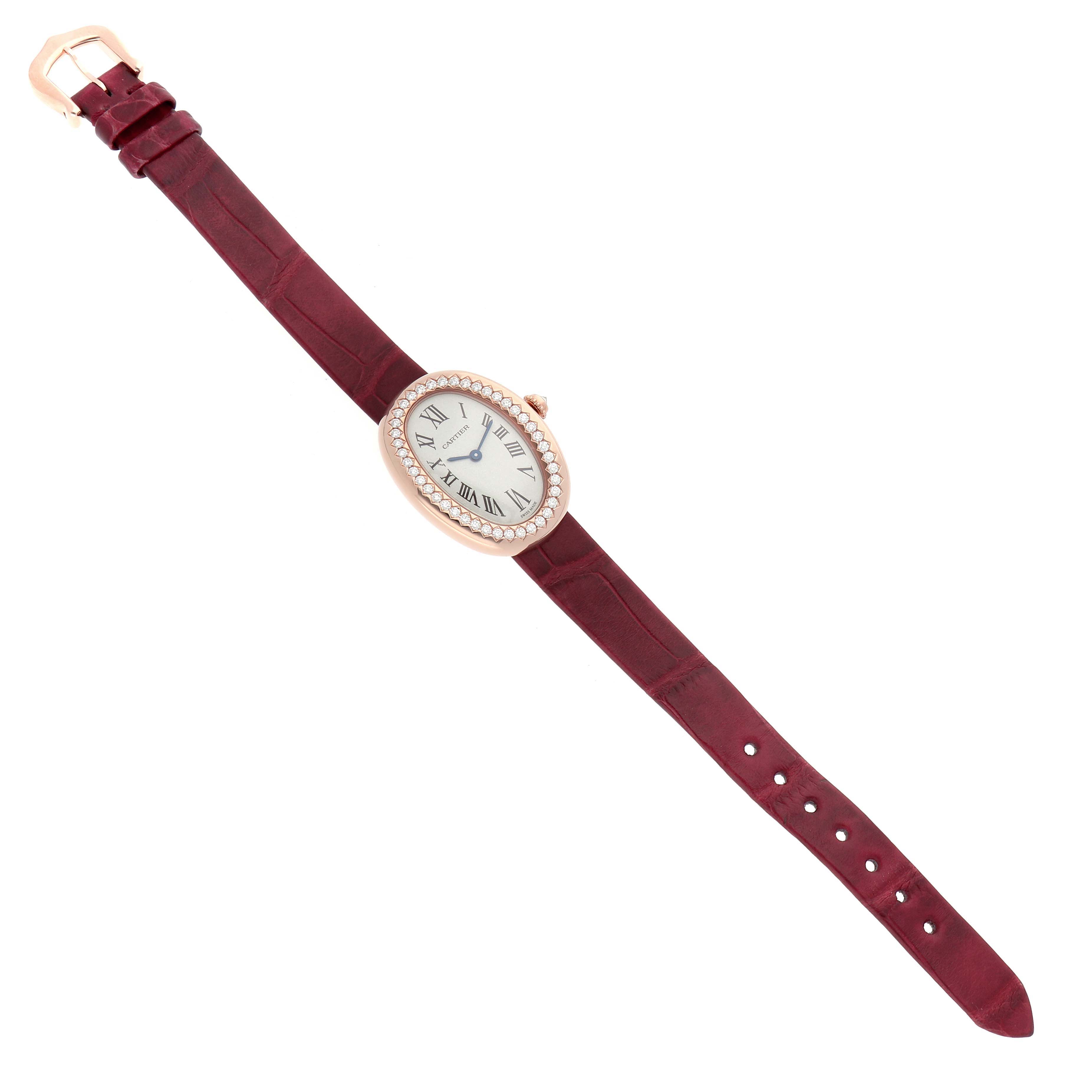 The Cartier Baignoire WJBA0031 Women's Rose Gold Silver Dial watch is shown from a top angle, revealing the oval face, diamond bezel, and burgundy strap.