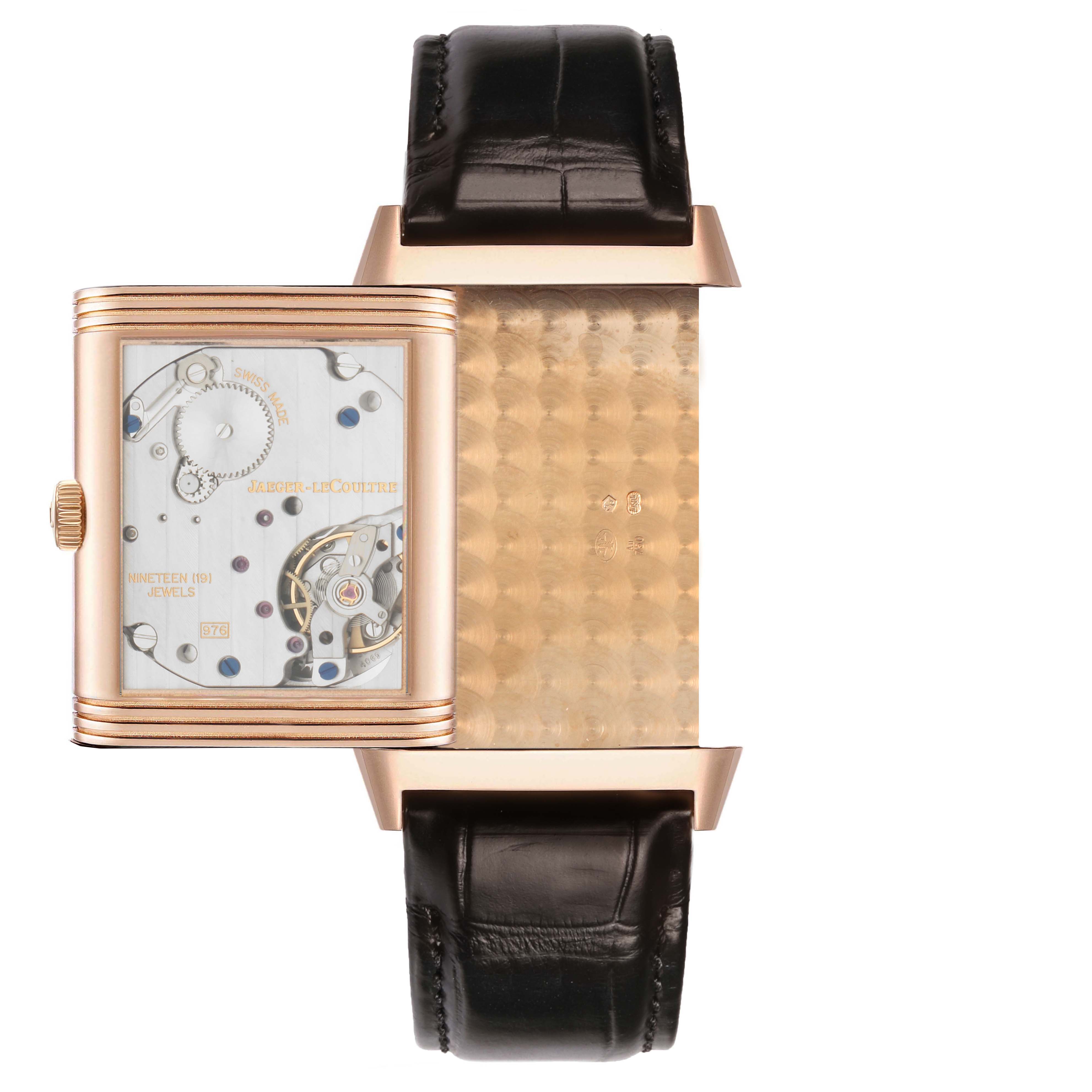 The Jaeger-LeCoultre Reverso watch is shown in partial open position, revealing the inner mechanism and part of the back case.