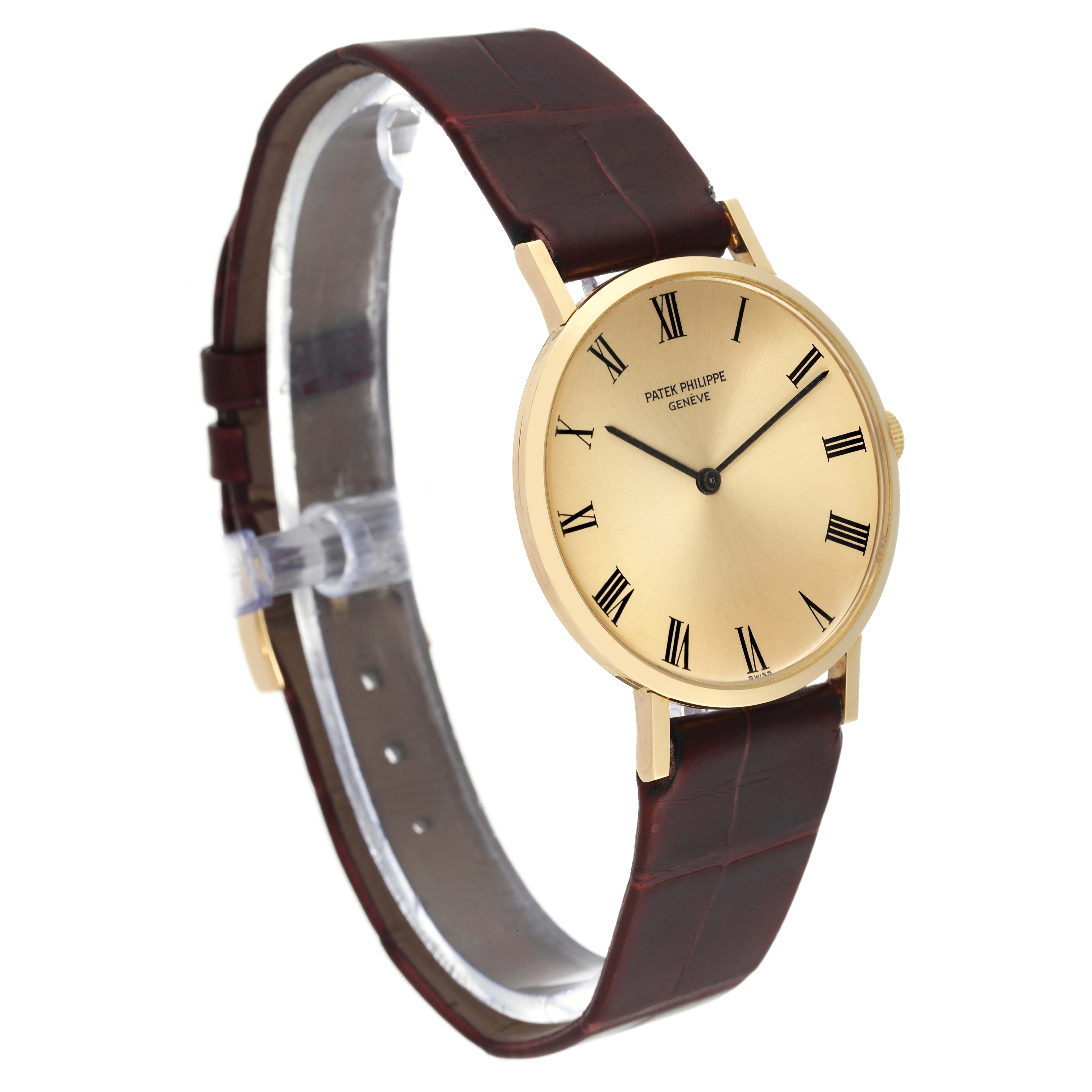 The image shows a Patek Philippe Calatrava 3537 Men
s Yellow Gold Champagne Dial 3537 Men
s Yellow Gold Champagne Dial watch at an angle, highlighting its round dial, gold case, and brown leather strap.