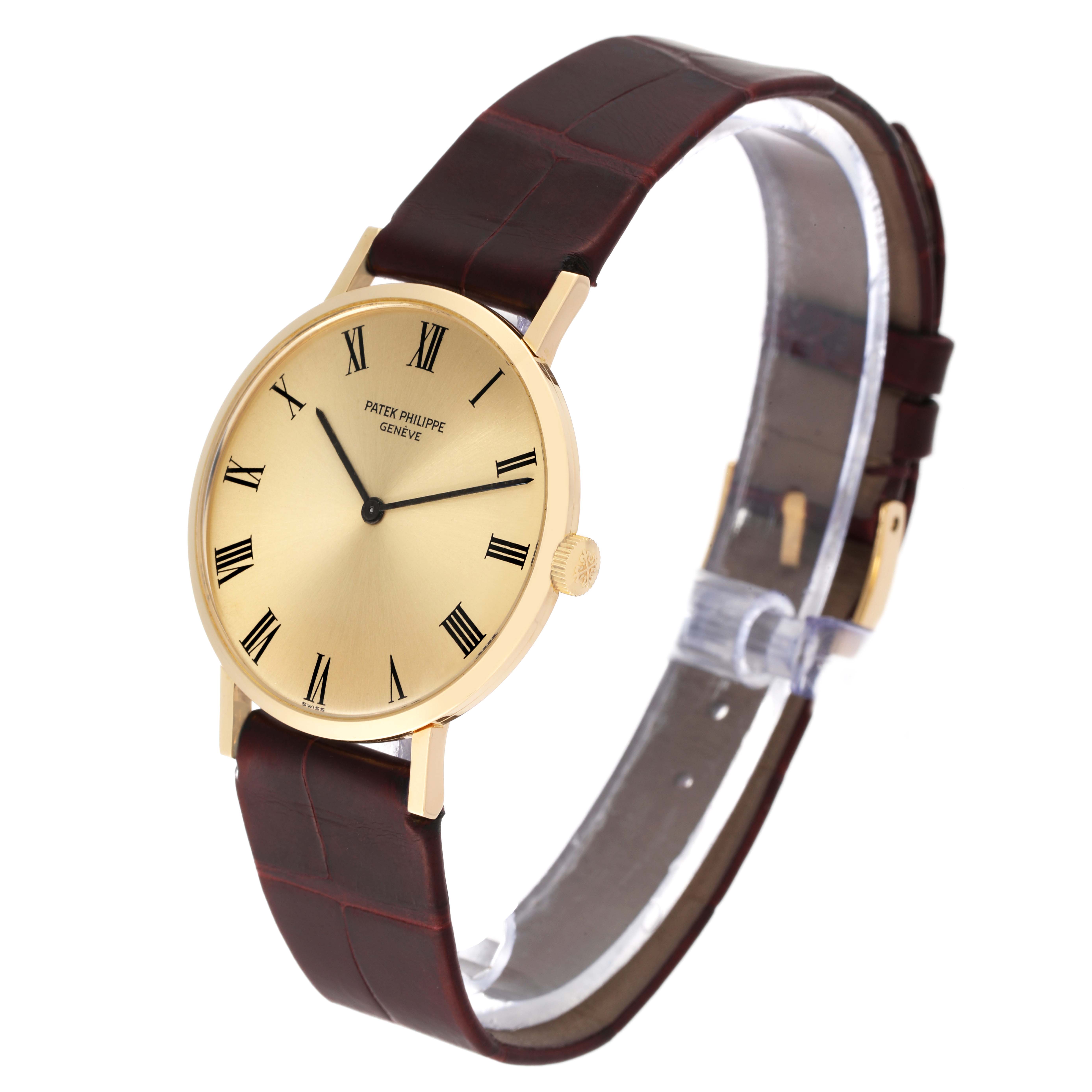 The image shows a side angle of a Patek Philippe Calatrava 3537 Men
s Yellow Gold Champagne Dial 3537 Men
s Yellow Gold Champagne Dial watch, highlighting its gold case, Roman numeral dial, and brown leather strap.