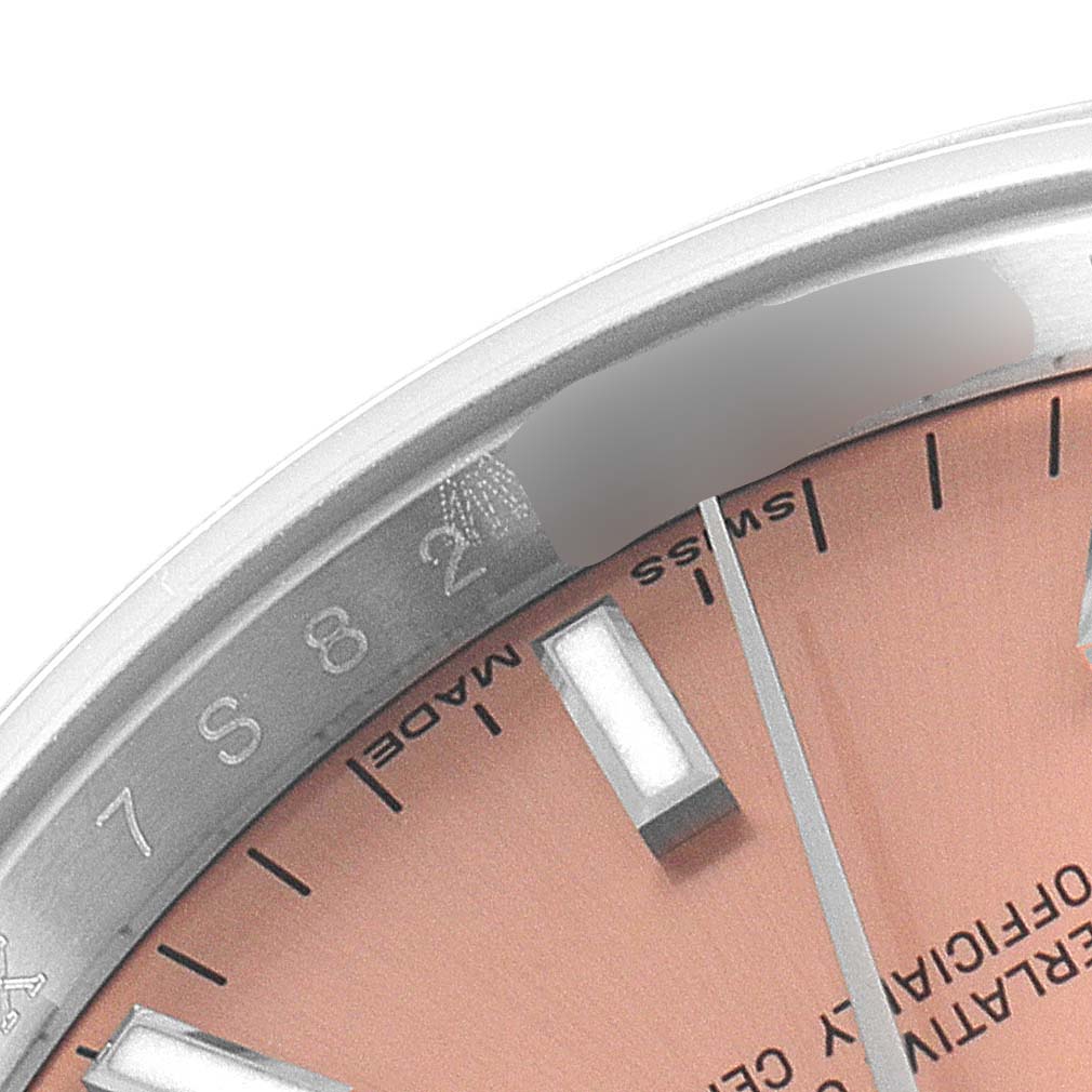 This close-up angle of the Rolex Date 115200 Men's Stainless Steel Pink Dial 115200 Men's Stainless Steel Pink Dial model shows a section of the dial, the hour markers, and part of the inner bezel.