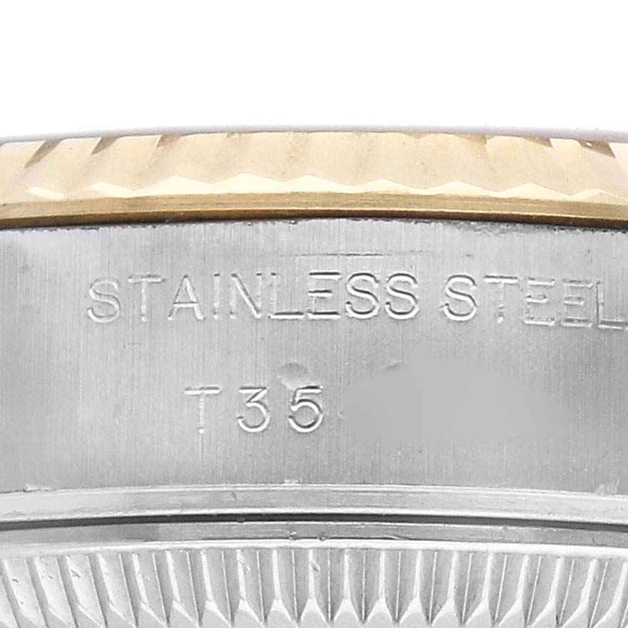 This close-up image of a Rolex Datejust 69173 Men's Steel and Gold (two tone) Champagne Dial shows the side of the bezel and part of the case, with "STAINLESS STEEL" engraved.