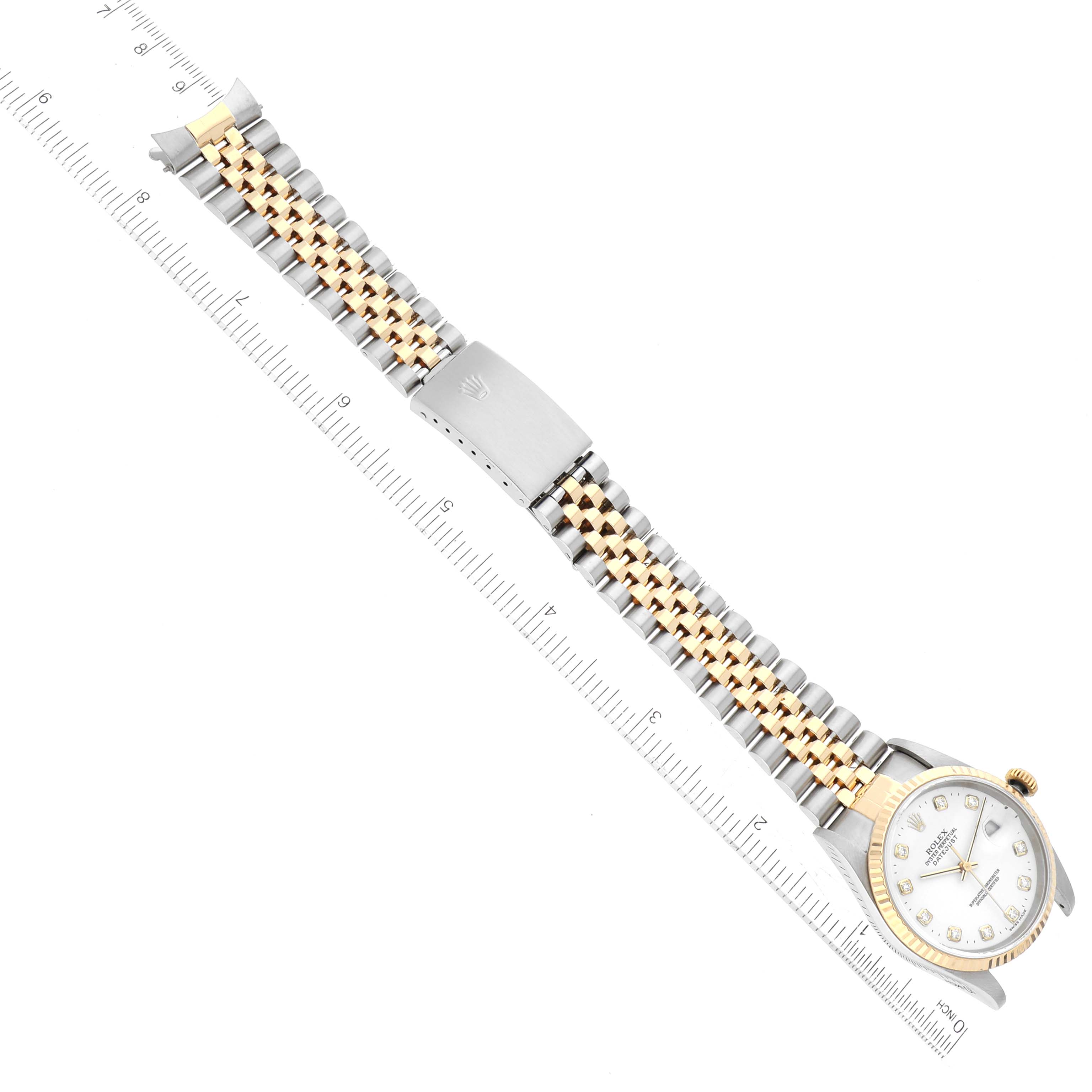 This image shows a top-down view of a Rolex Datejust 16233 Men's Steel and Gold (two tone) White Dial 16233 Men's Steel and Gold (two tone) White Dial watch with a ruler placed alongside it for scale.