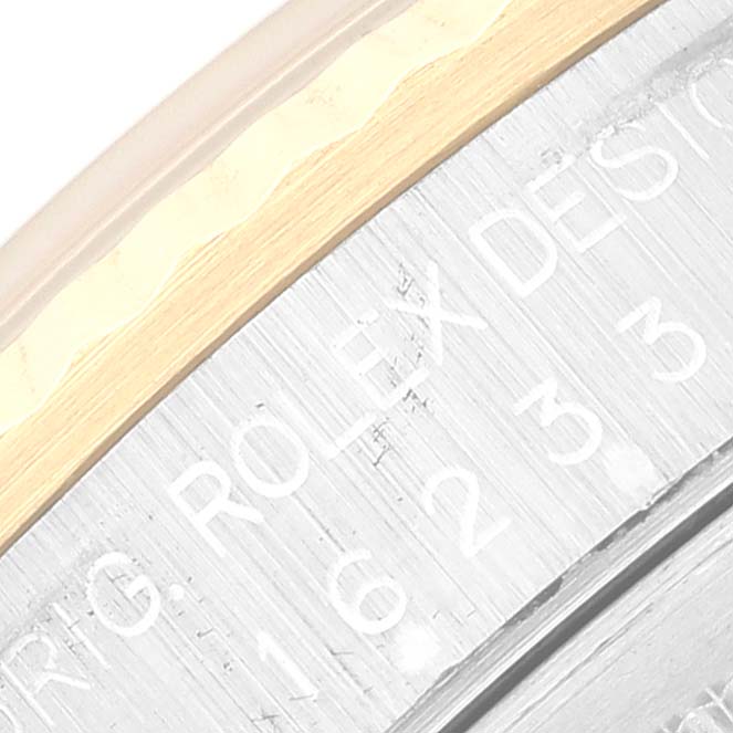 Close-up of the Rolex Datejust 16233 Men's Steel and Gold (two tone) White Dial 16233 Men's Steel and Gold (two tone) White Dial watch case showing engraved text and part of the bezel edge.