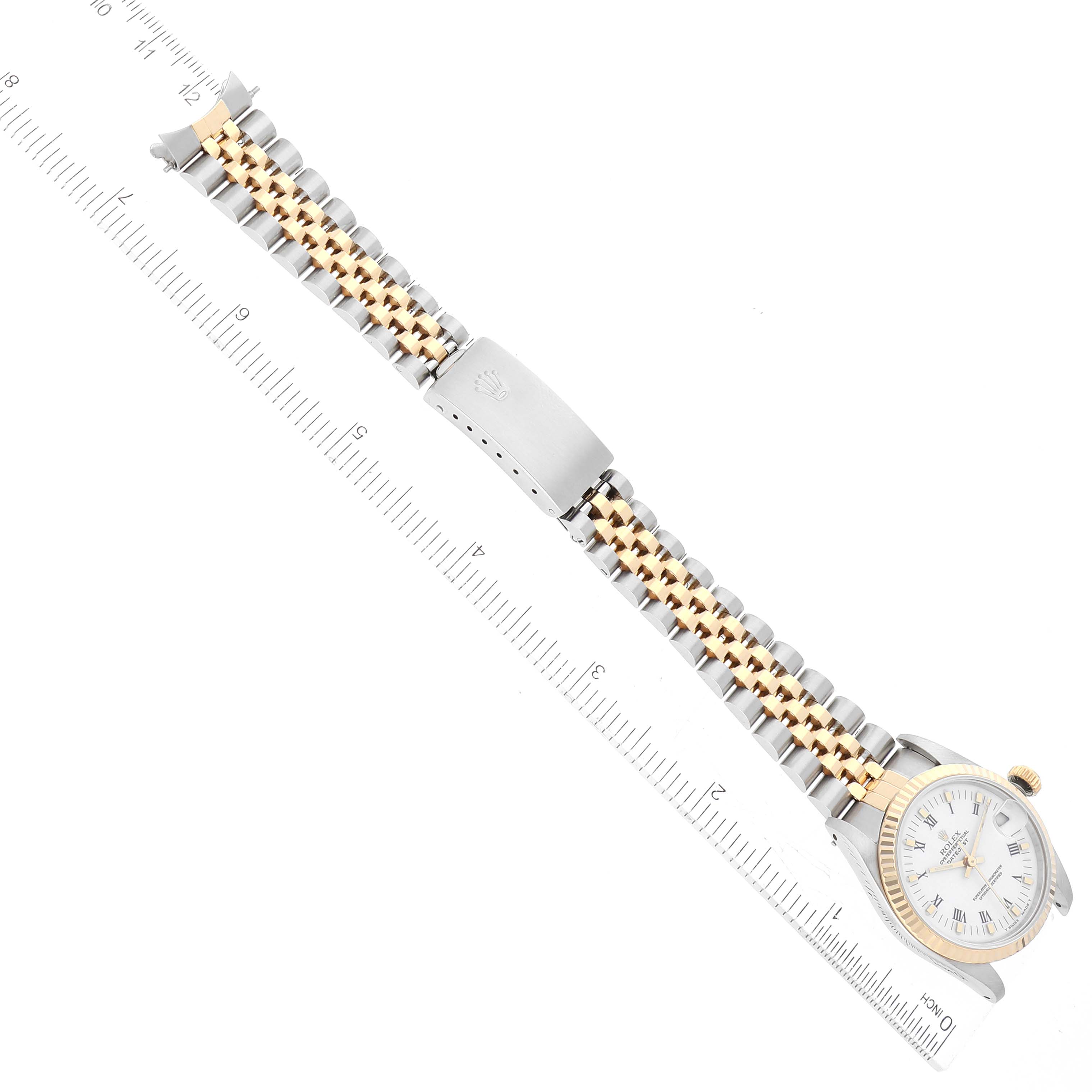 The image shows a flat-lay view of a Rolex Mid-Size 68273 Women
s Steel and Gold (two tone) White Dial 68273 Women
s Steel and Gold (two tone) White Dial watch, focusing on the entire watch and bracelet, with a ruler alongside.