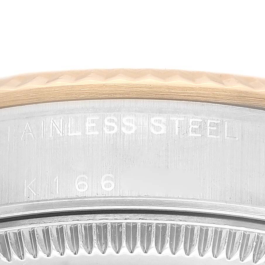 The image shows a close-up of the case side and part of the bezel of a Mid-Size Rolex watch, highlighting the stainless steel engraving.
