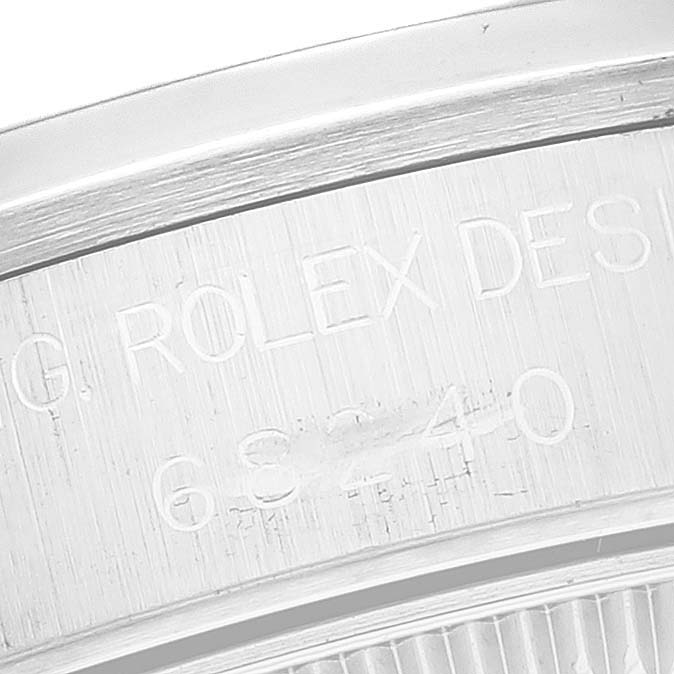 This image shows an angled close-up of the engravings on the inner bezel of a Rolex Mid-Size 68240 Women
s Stainless Steel White Dial 68240 Women
s Stainless Steel White Dial model watch.