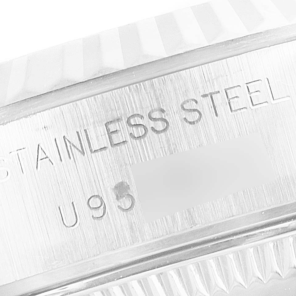 This image shows a close-up of the side and bottom rim of the fluted bezel of a Rolex Datejust 69174 Women's Stainless Steel Mother of Pearl Dial 69174 Women's Stainless Steel Mother of Pearl Dial, revealing the "Stainless Steel" engraving.