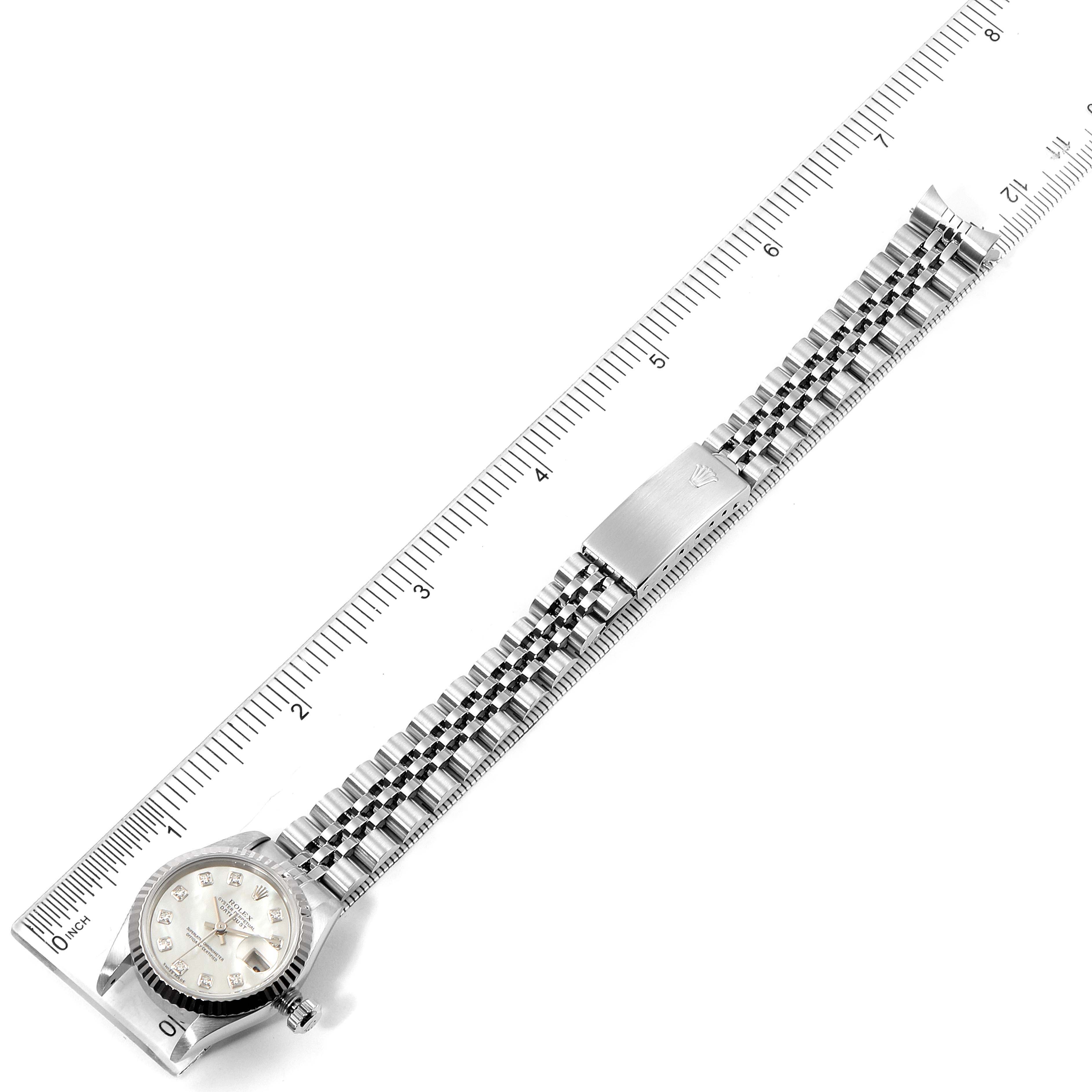 The image shows a top view of a Rolex Datejust 69174 Women's Stainless Steel Mother of Pearl Dial 69174 Women's Stainless Steel Mother of Pearl Dial watch, displaying the face, bezel, crown, and Jubilee bracelet against a ruler for scale.