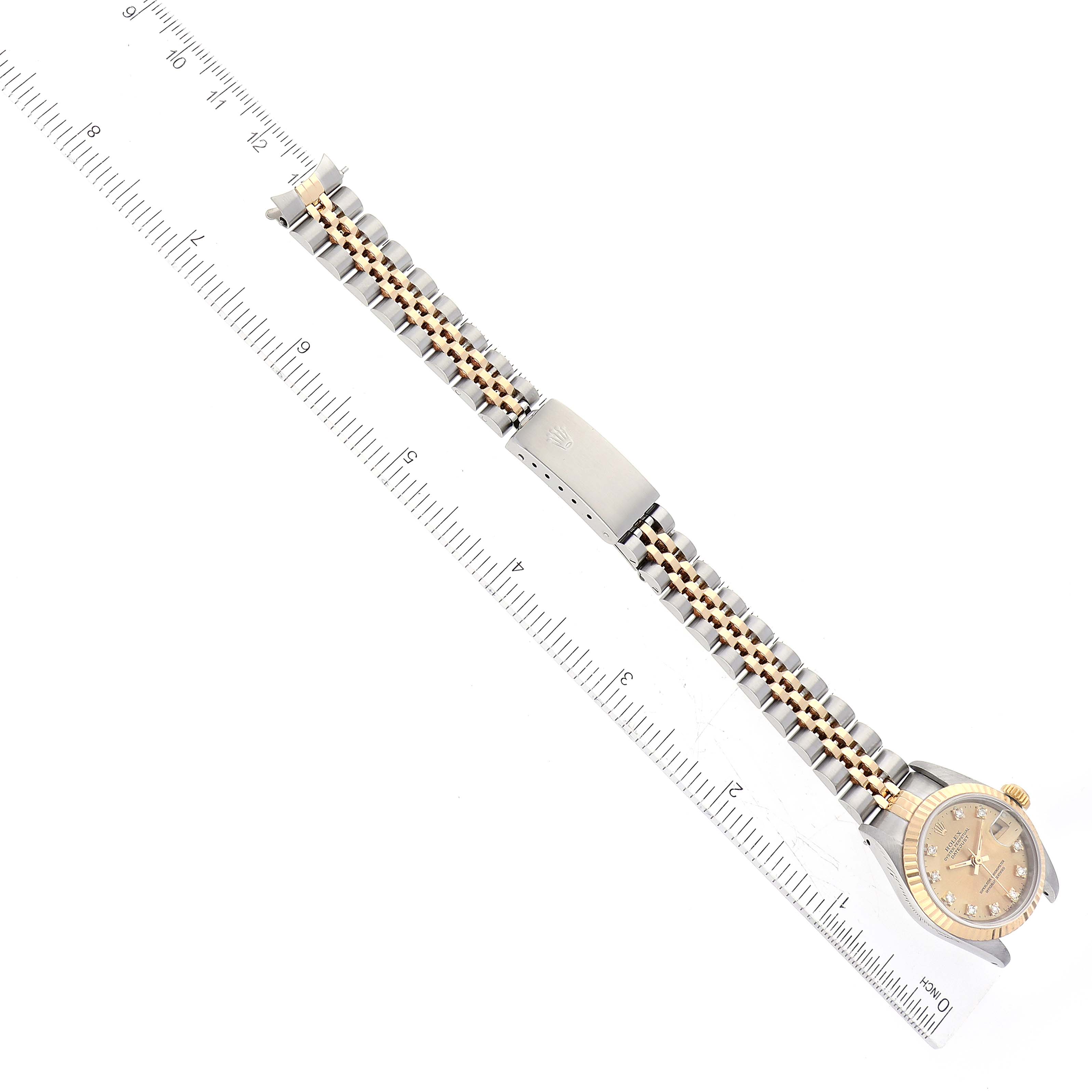 The image displays a Rolex Datejust 69173 Women's Steel and Gold (two tone) Champagne Dial 69173 Women's Steel and Gold (two tone) Champagne Dial watch laid flat alongside a ruler, showing the face, bracelet, and clasp.