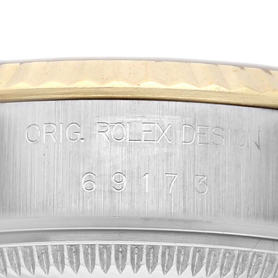 The image shows a close-up side view of the Rolex Datejust 69173 Women's Steel and Gold (two tone) Champagne Dial 69173 Women's Steel and Gold (two tone) Champagne Dial watch, focusing on the engraved case details and fluted bezel.