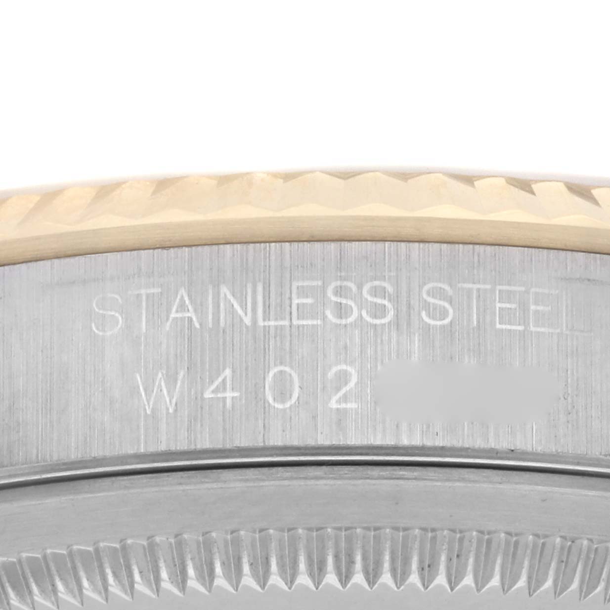 The image shows a close-up of the Rolex Datejust 16233 Men
s Steel and Gold (two tone) Champagne Dial 16233 Men
s Steel and Gold (two tone) Champagne Dial
s stainless steel case with engravings near the bezel edge.