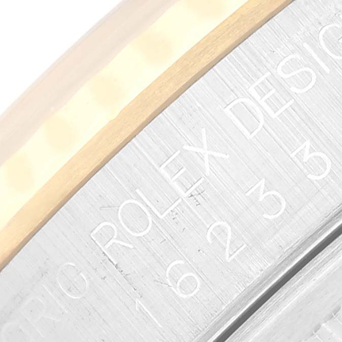 This close-up angle shows part of the outer rim and edge engraving of the Rolex Datejust 16233 Men's Steel and Gold (two tone) White Dial 16233 Men's Steel and Gold (two tone) White Dial watch.